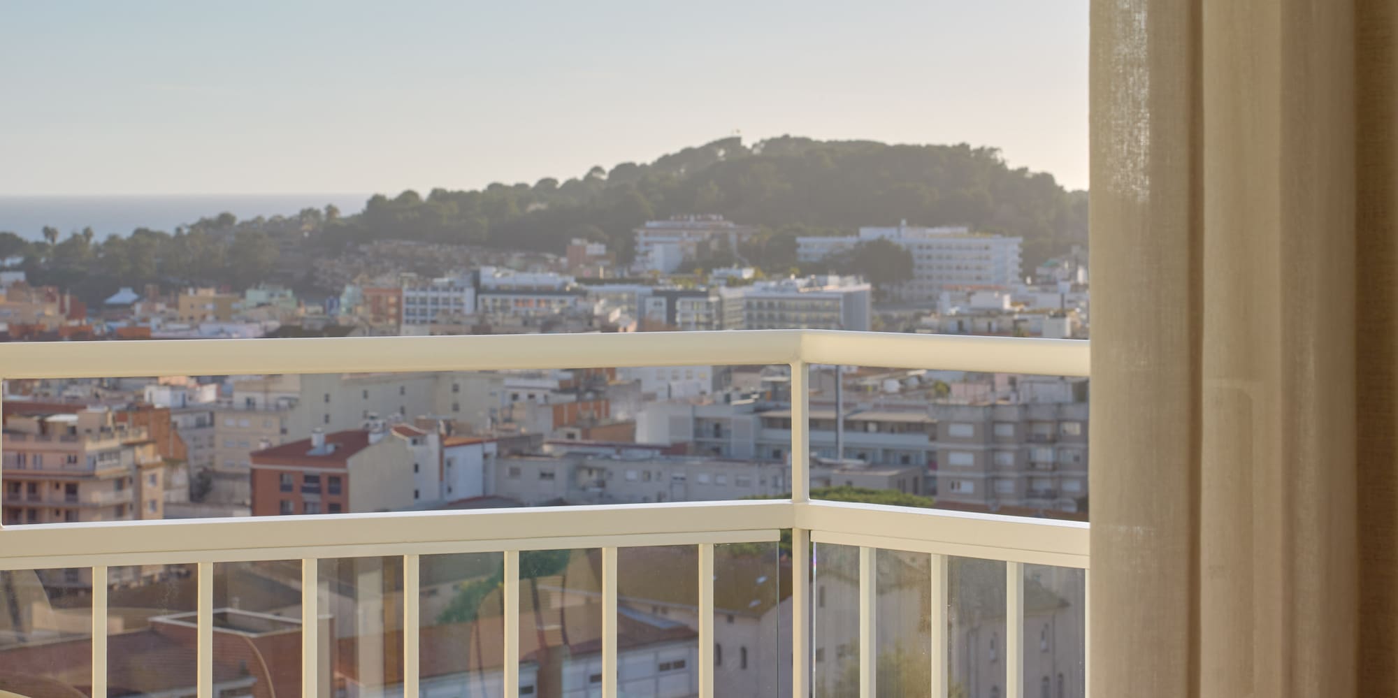 a balcony with a view of a city and a beach
