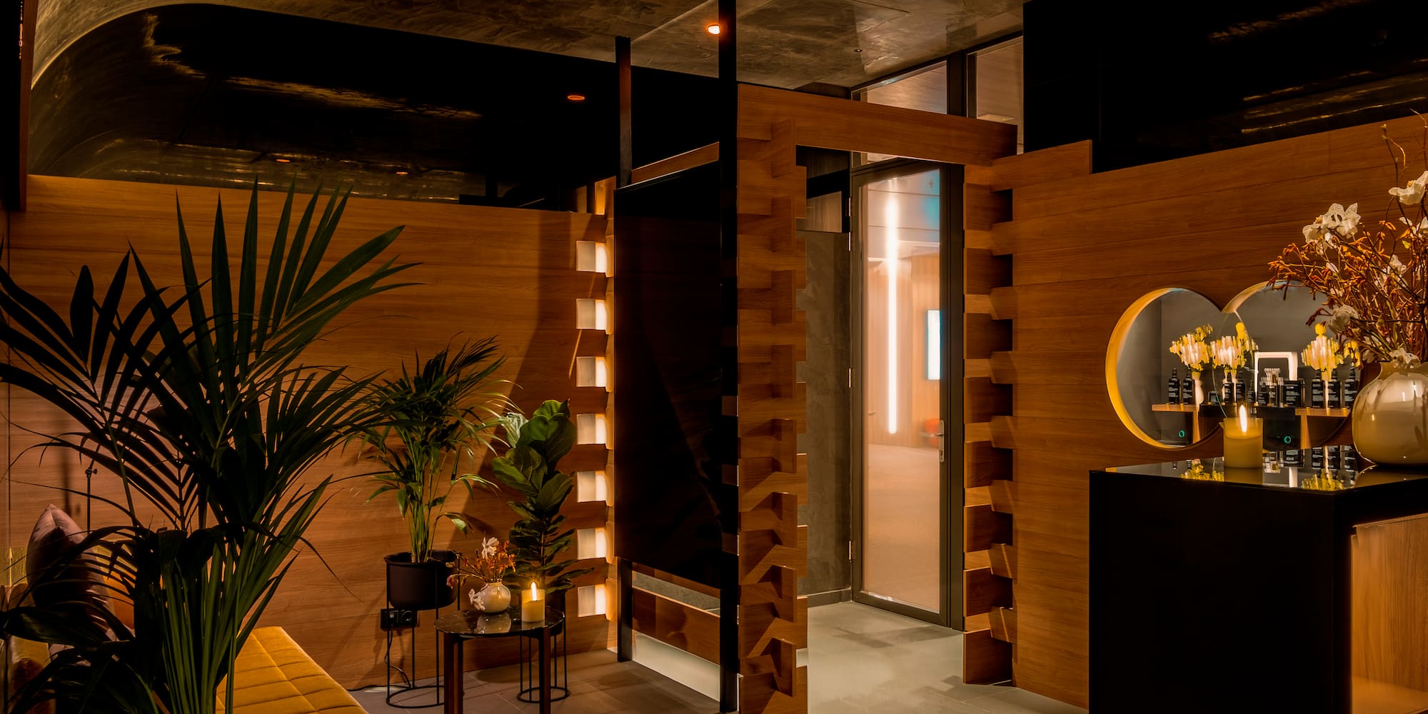 a room with a wood wall and a bench and a table with plants