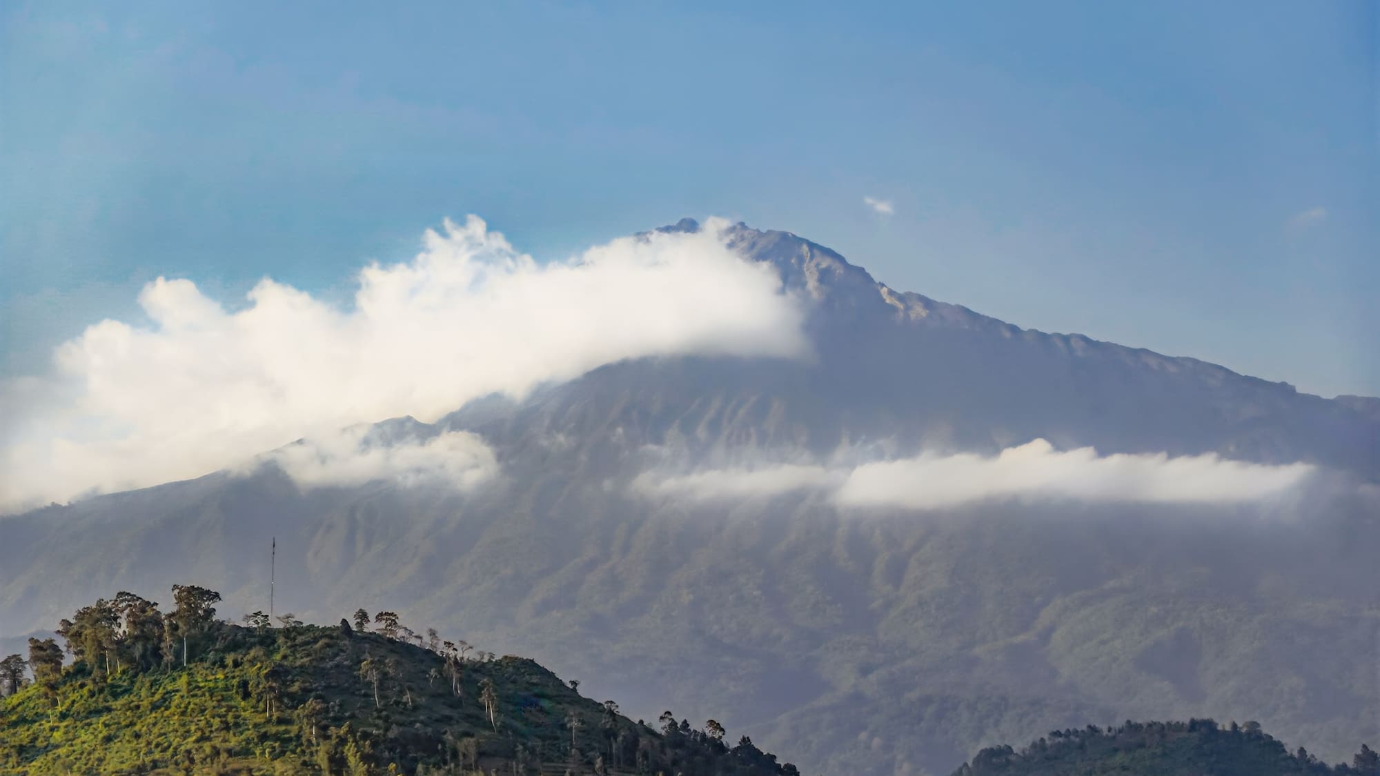 a mountain with clouds in the sky