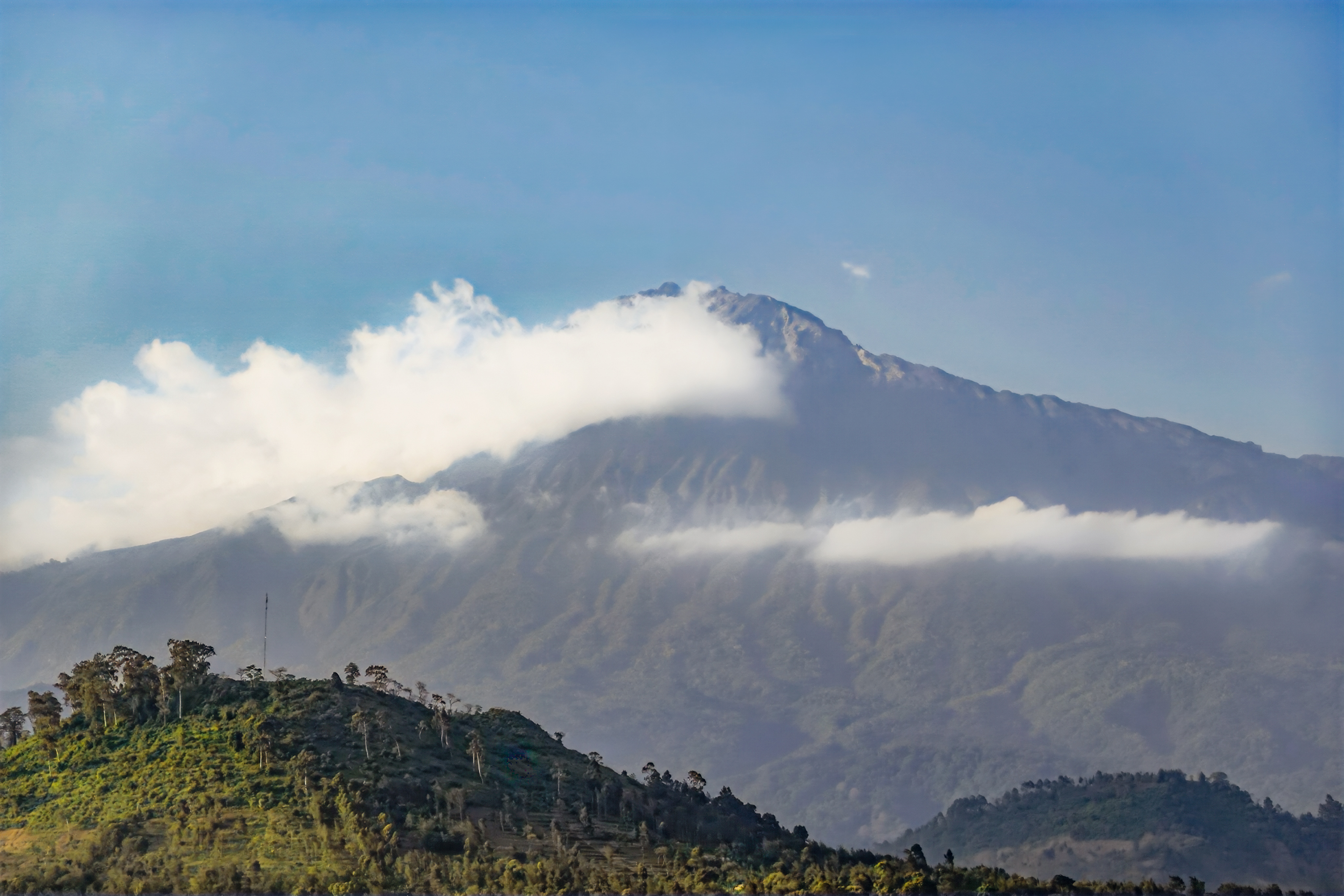 a mountain with clouds in the sky