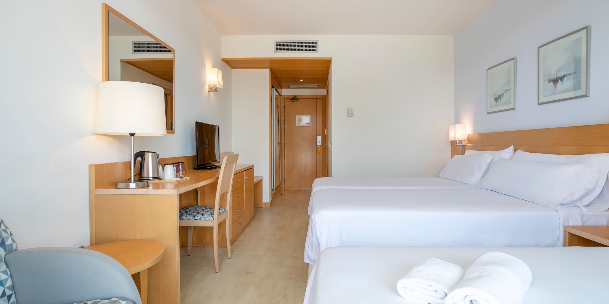 a room with two beds and a desk