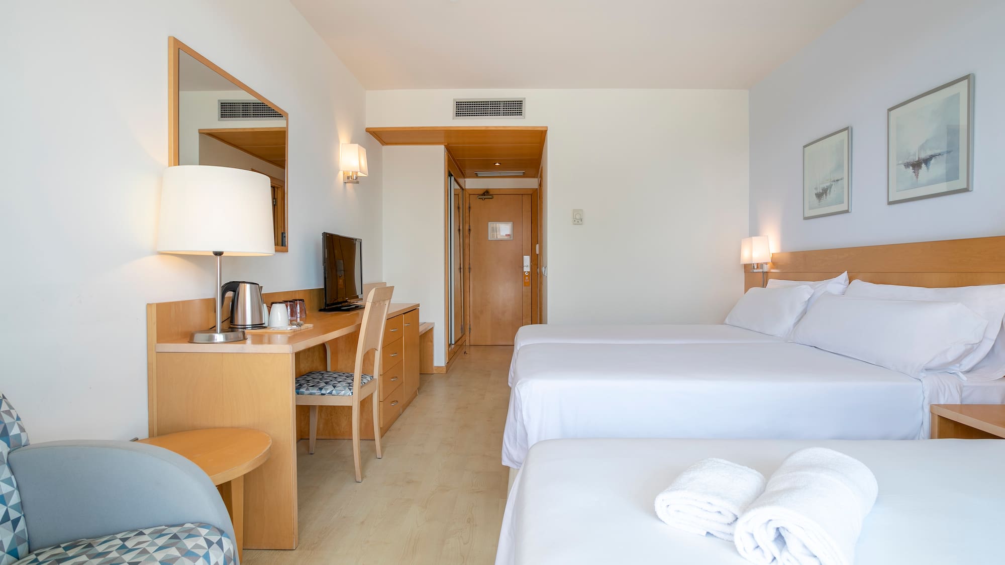 a room with two beds and a desk