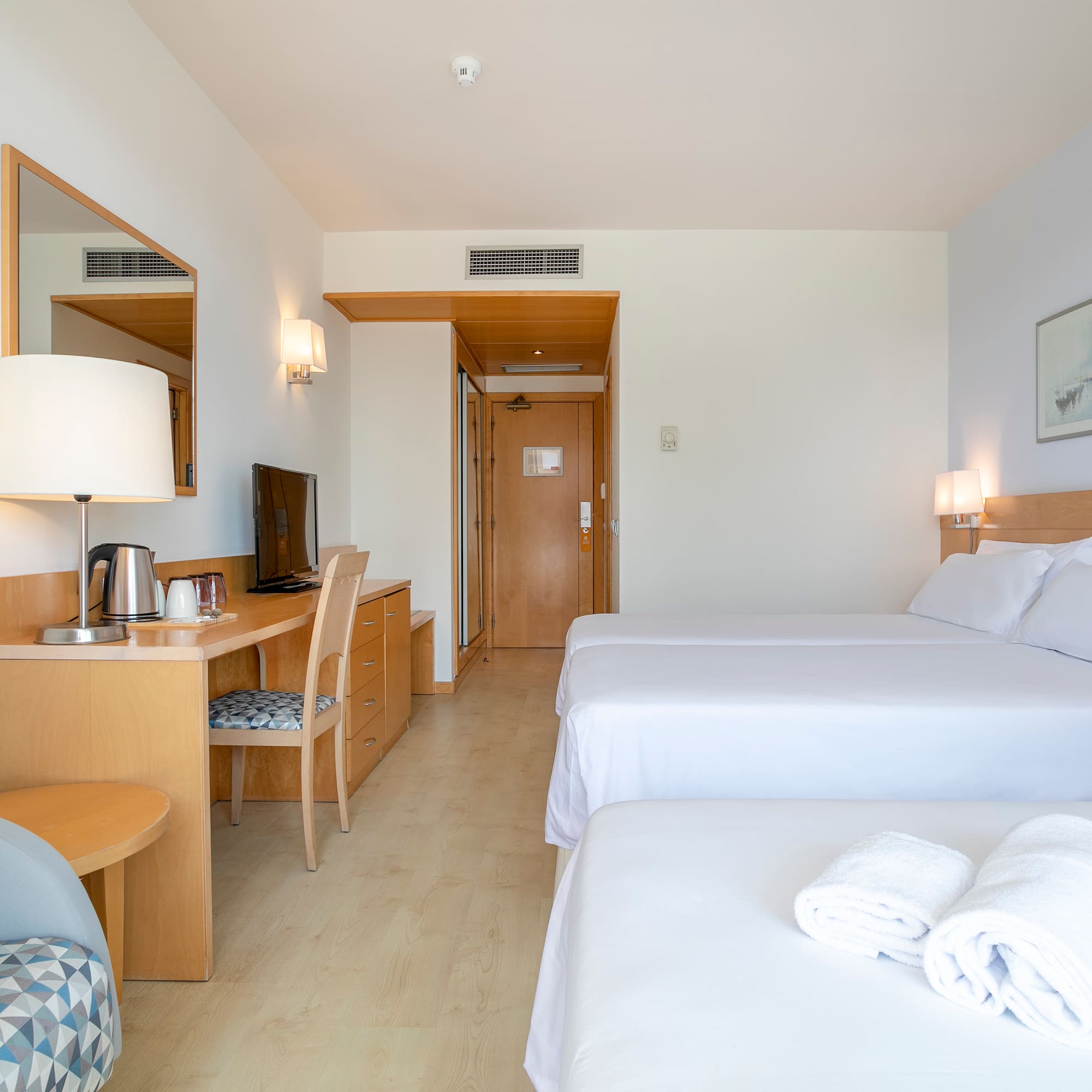 a room with two beds and a desk