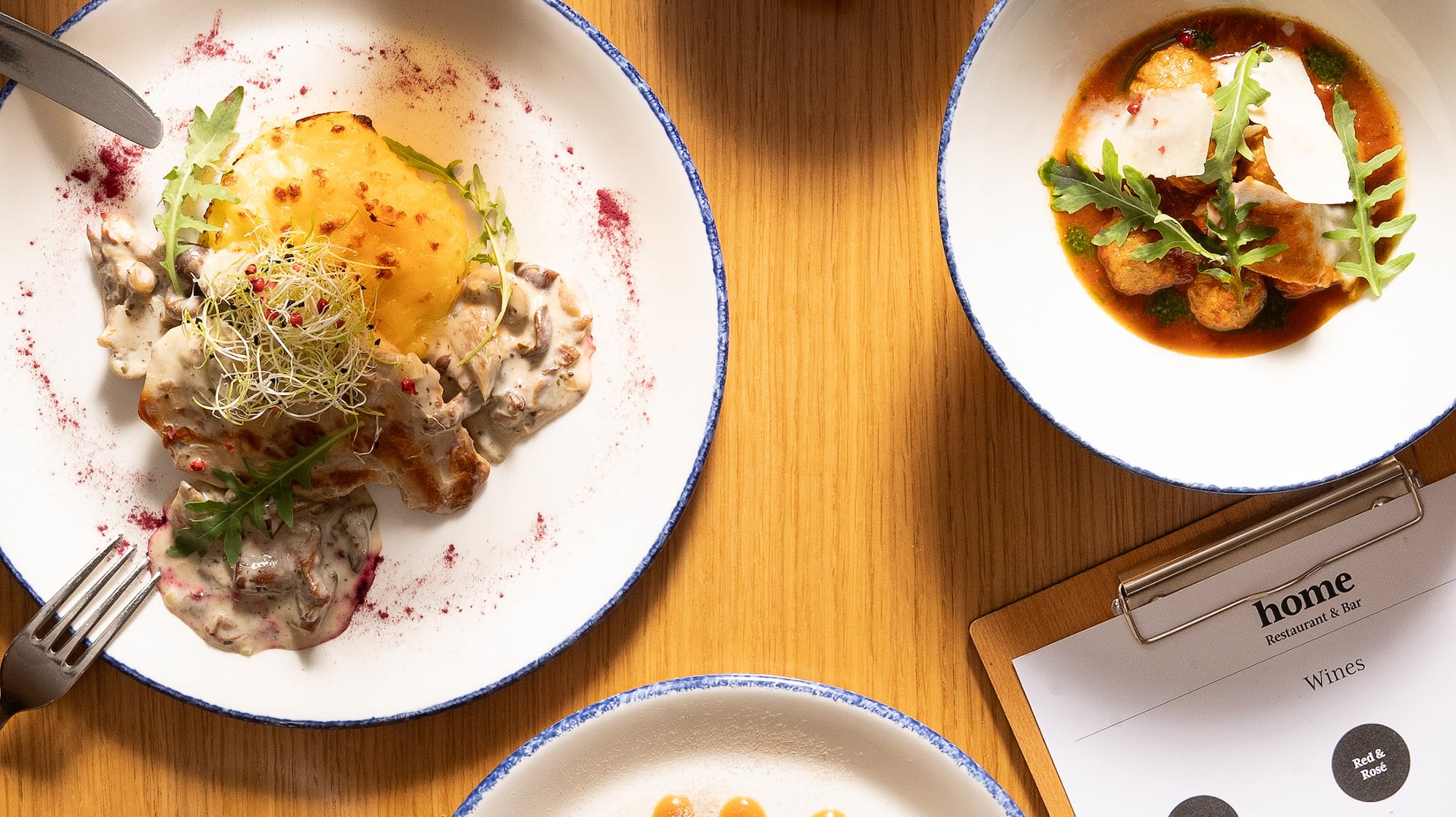 a table with plates of food and glasses of beer