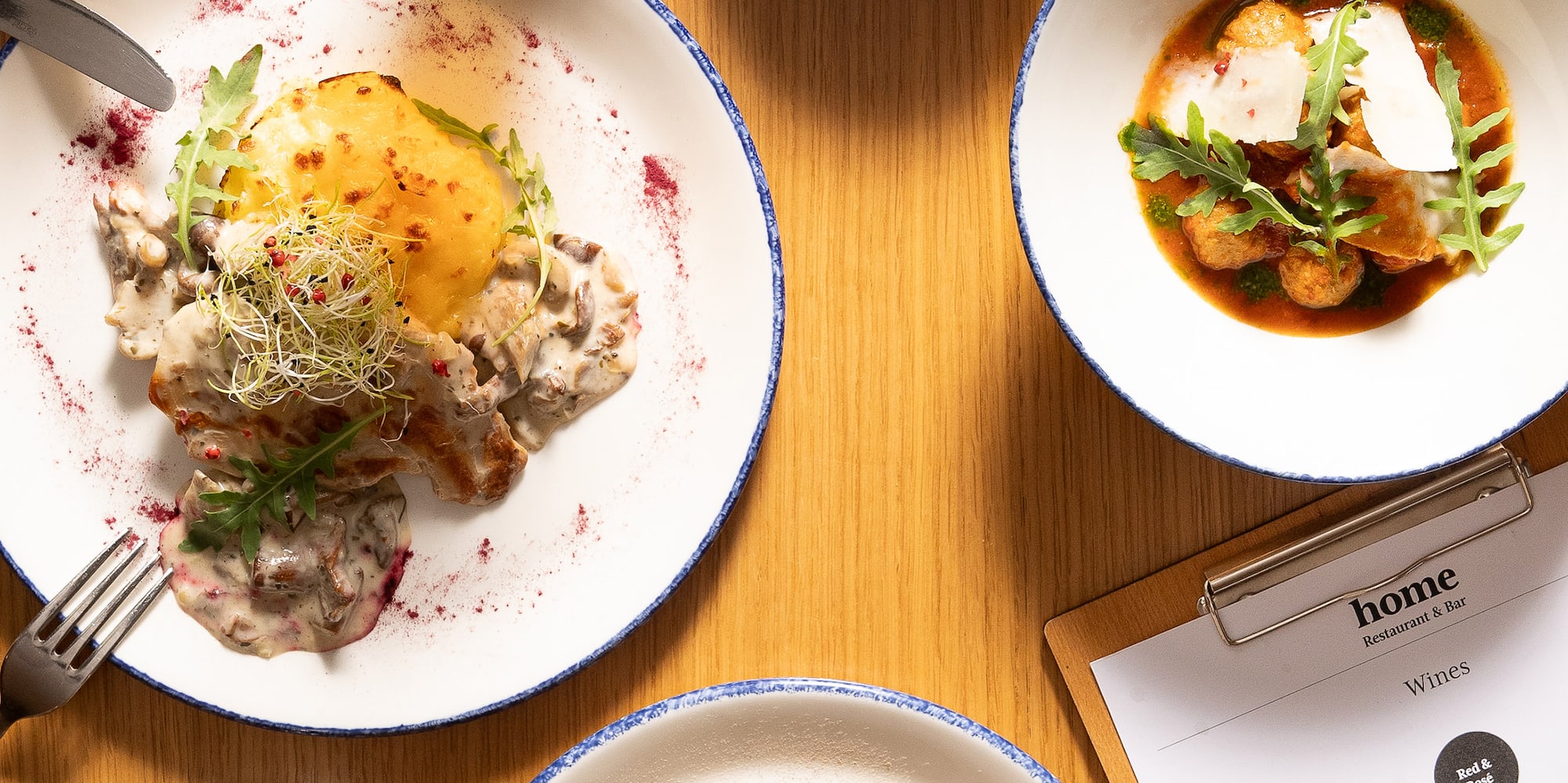 a table with plates of food and glasses of beer