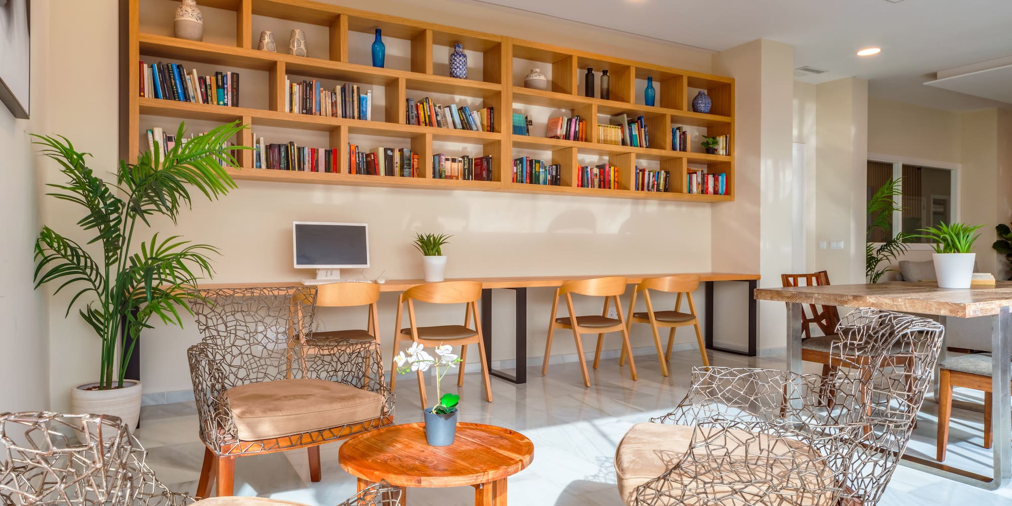 a room with a table and chairs and bookshelves