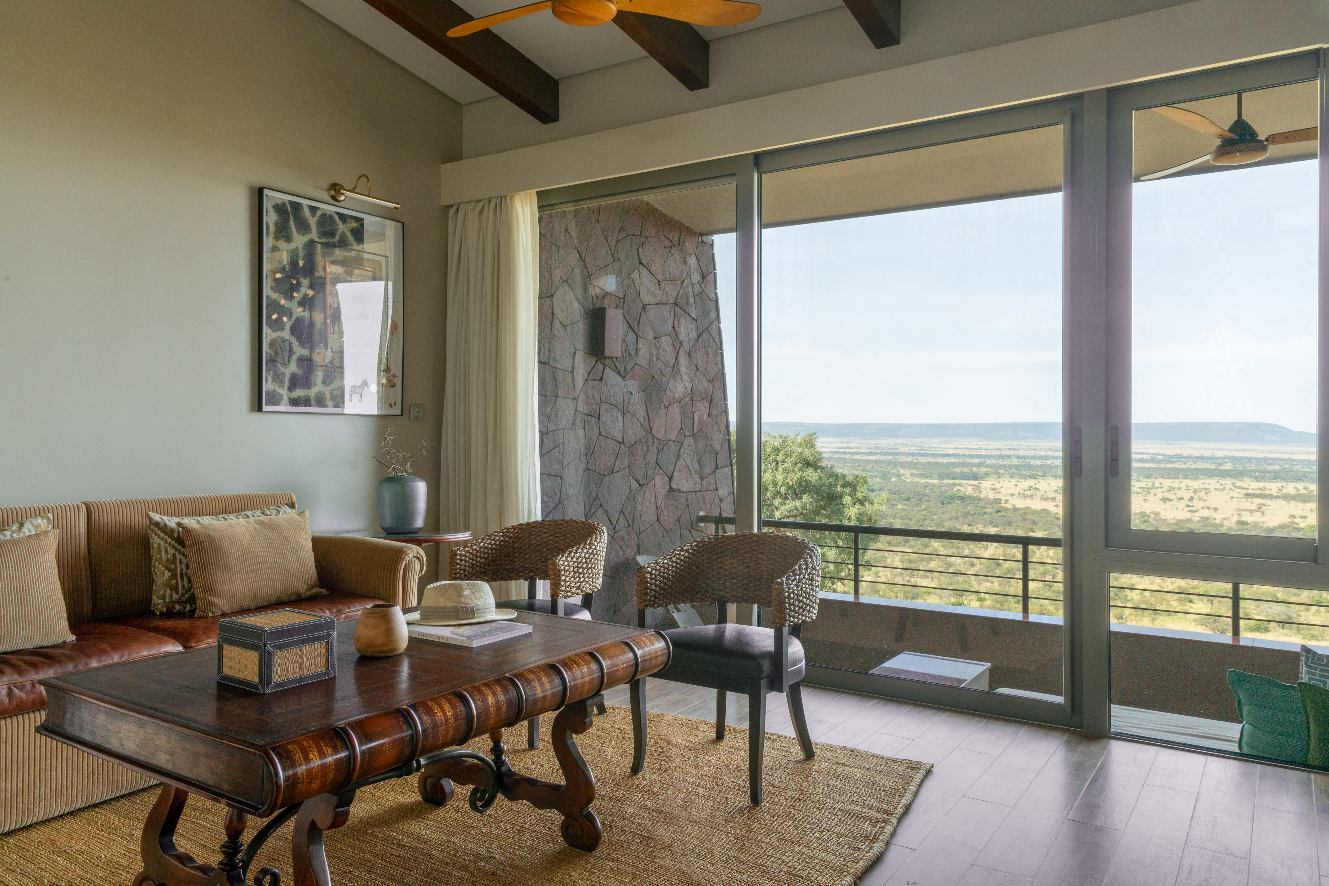Luxury safari lodge living room with panoramic savanna views and natural decor.