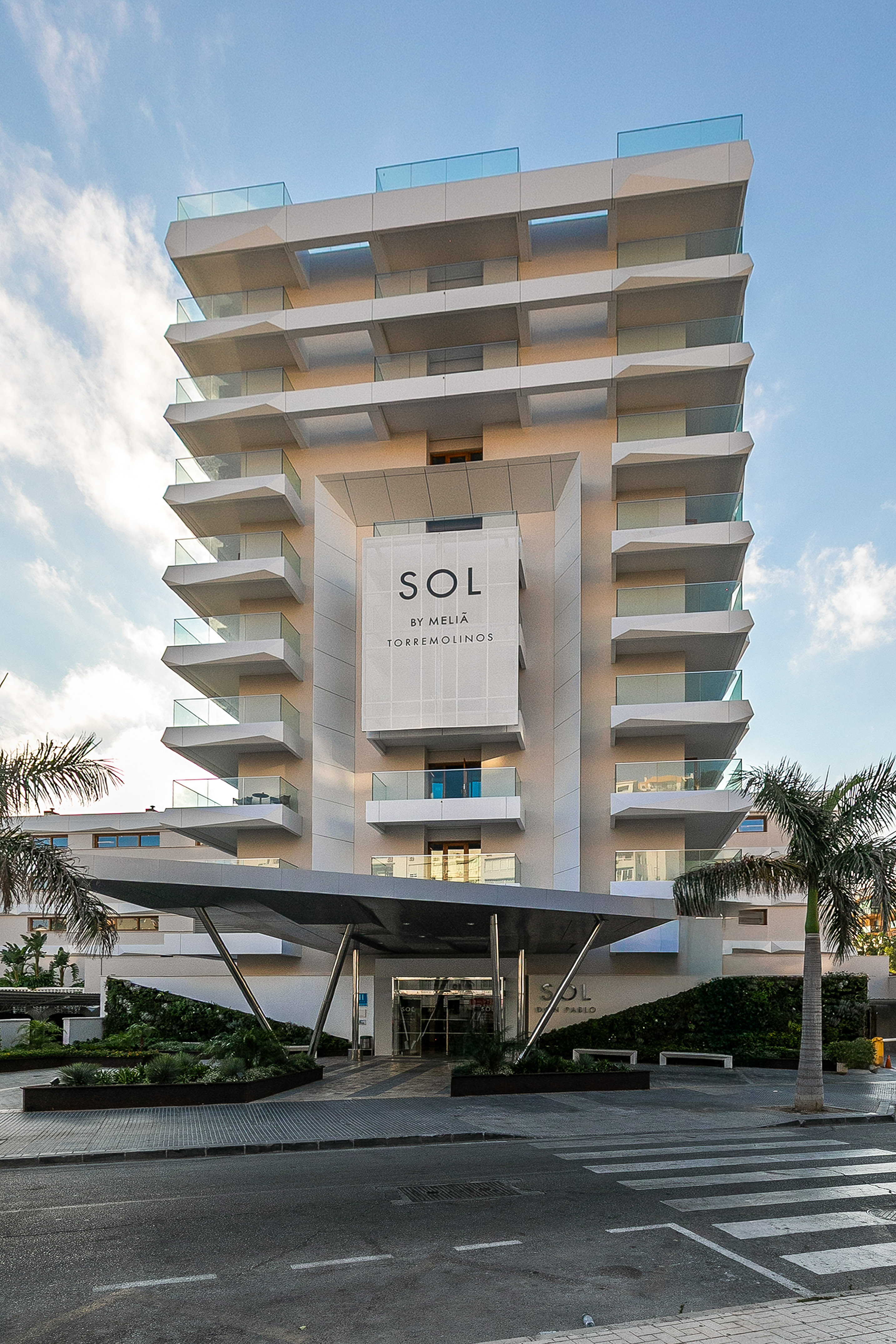 Sol by Meliá Torremolinos hotel with modern balconies & palm trees.