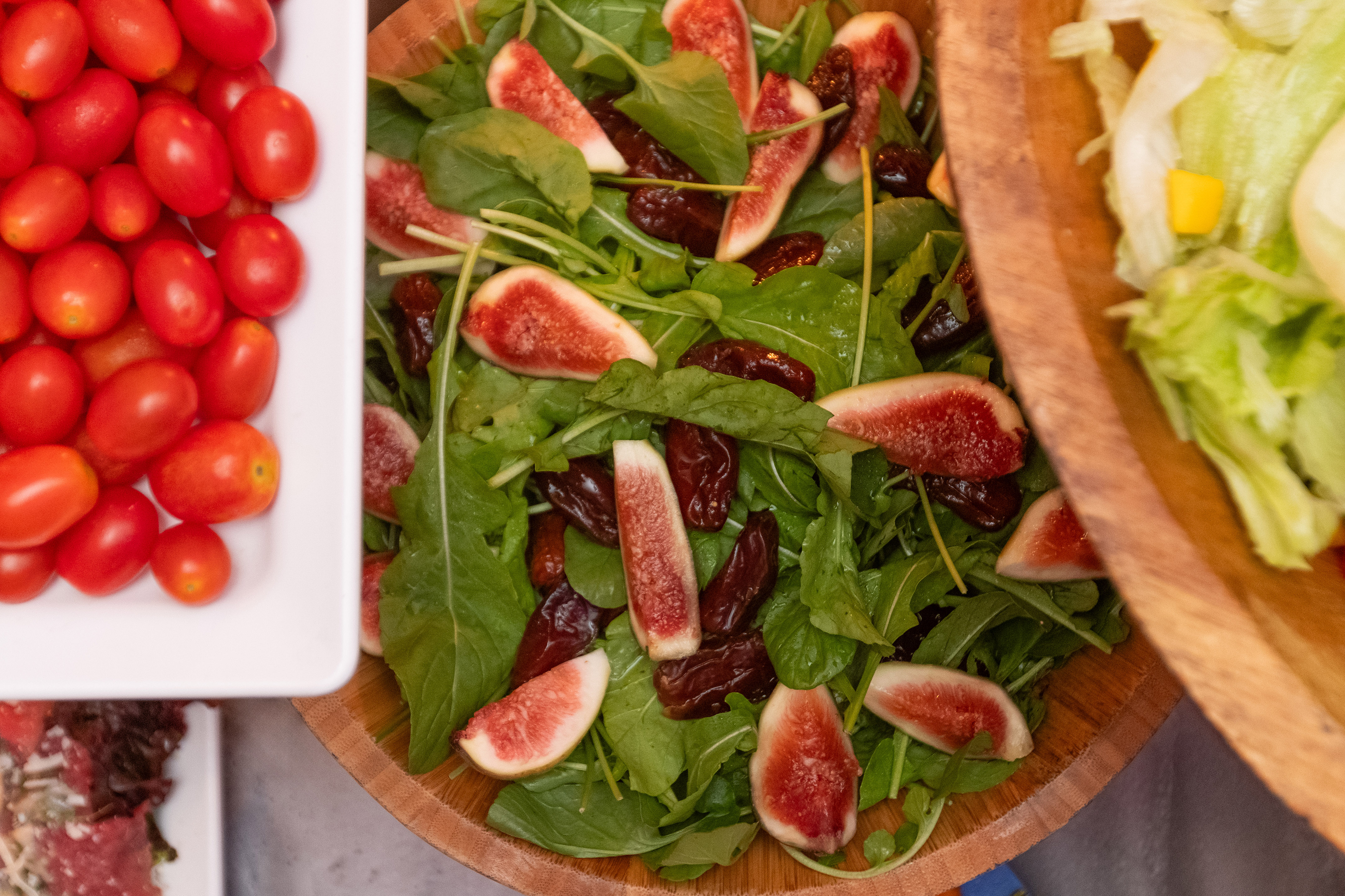 a bowl of salad with figs and tomatoes