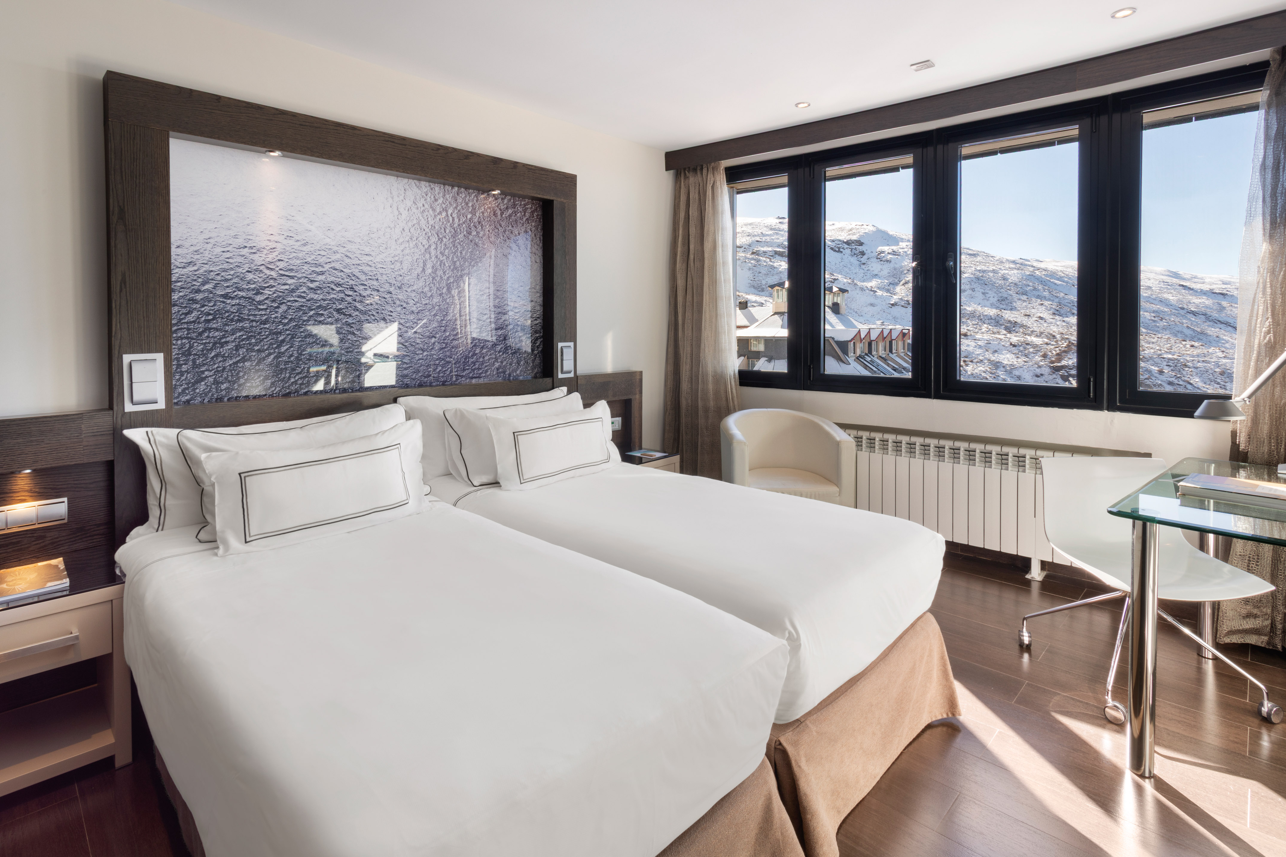 Ski resort twin room with snowy mountain view and large window.