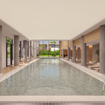 a large indoor pool with columns and a large walkway