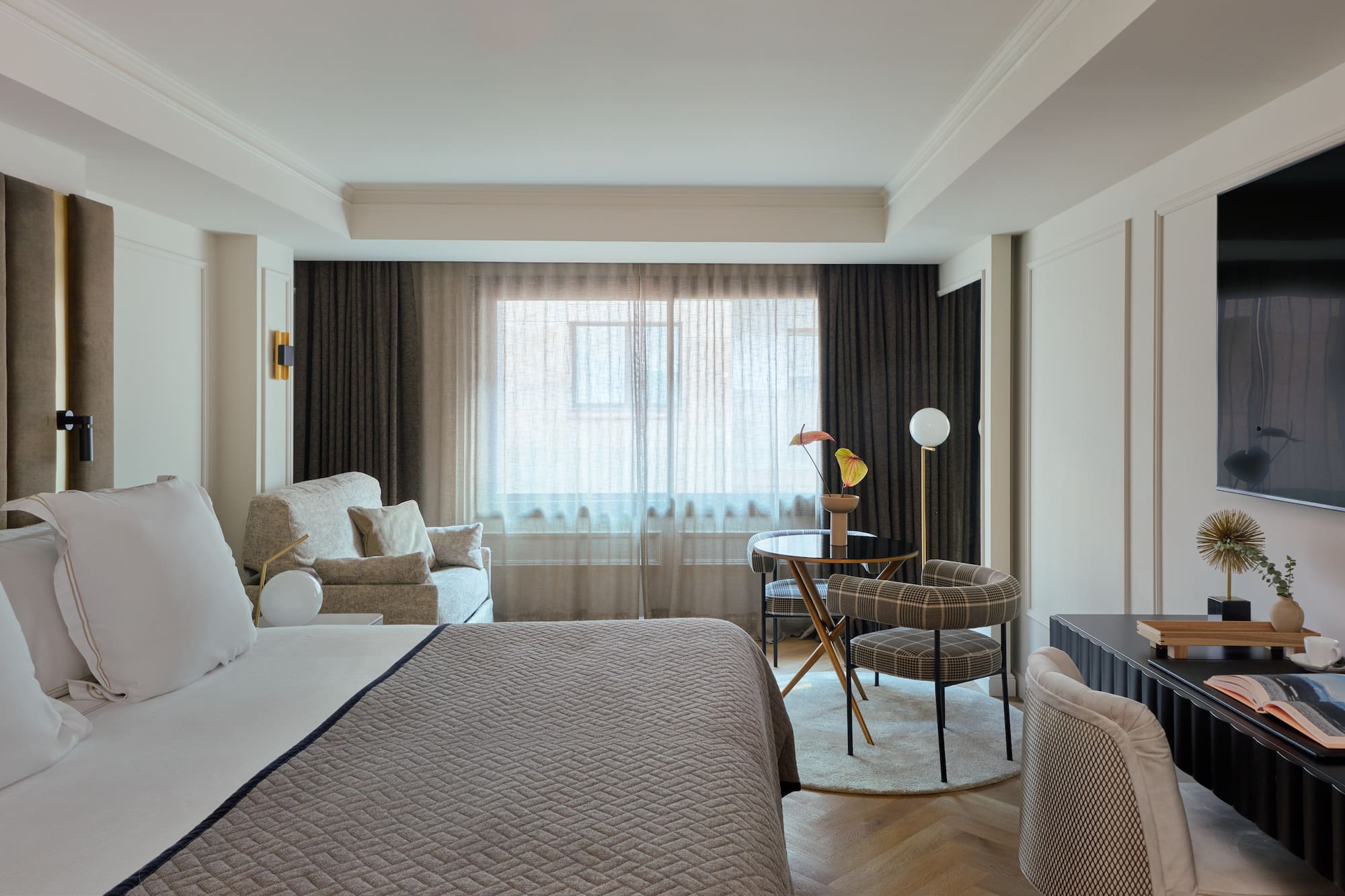 a bedroom with a bed and a table and chairs