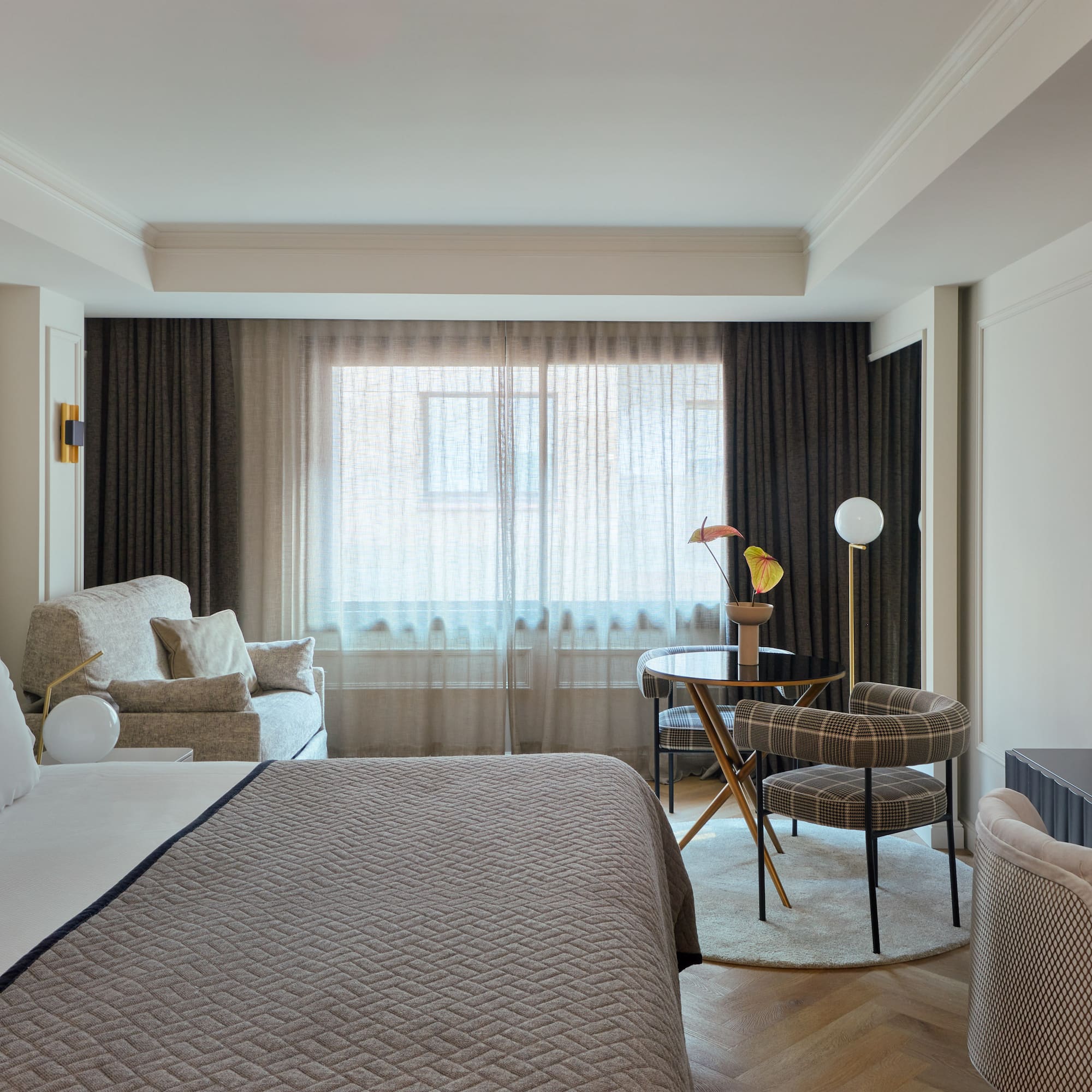 a bedroom with a bed and a table and chairs