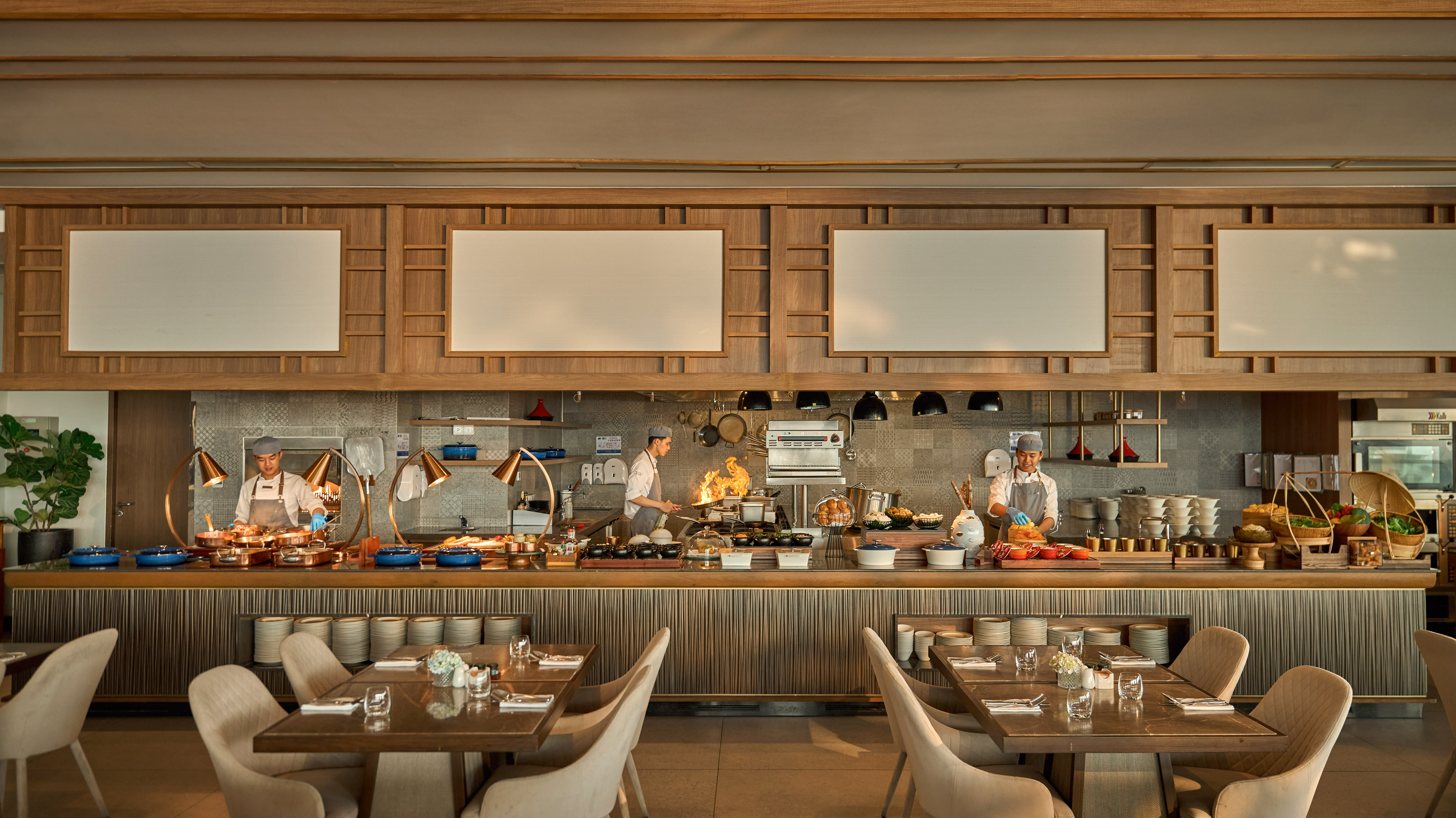 Modern restaurant buffet with live cooking chefs at food stations.