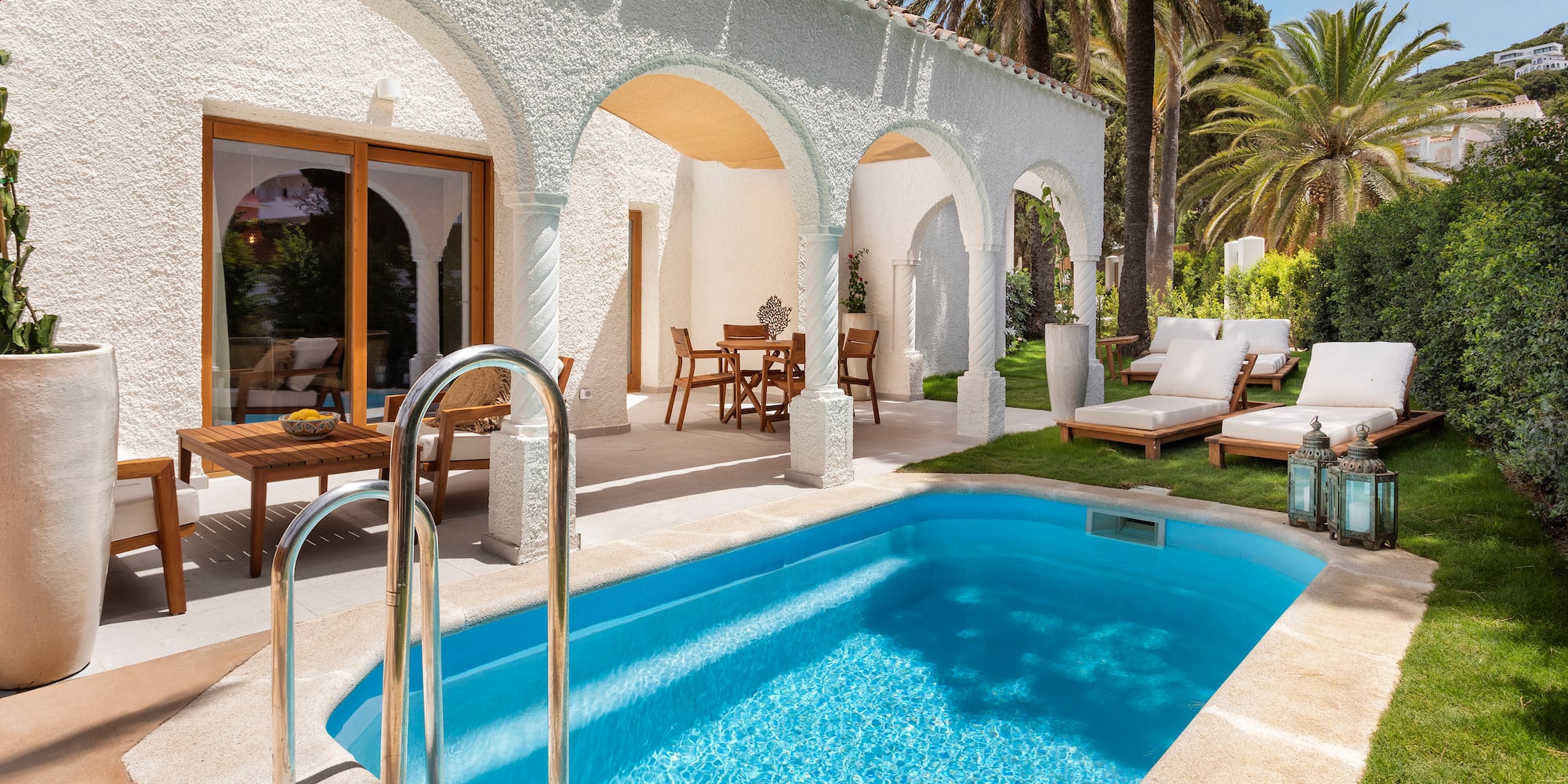 a swimming pool and a patio with chairs and a deck