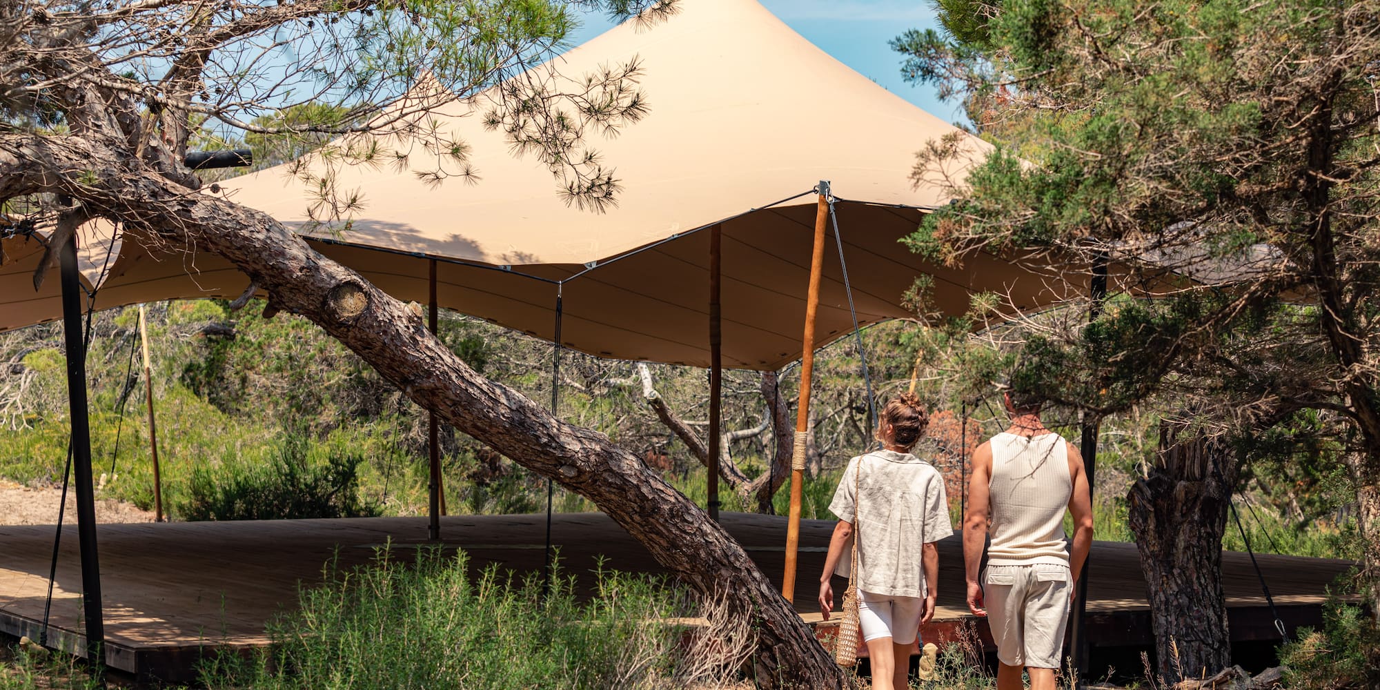two people walking under a tent