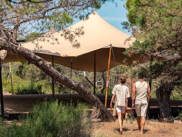 two people walking under a tent