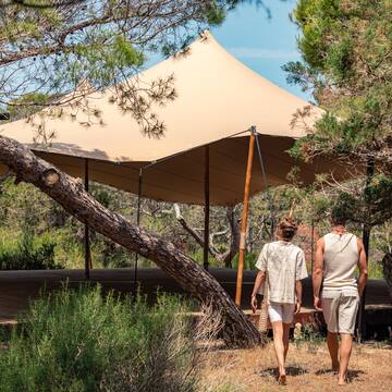 two people walking under a tent