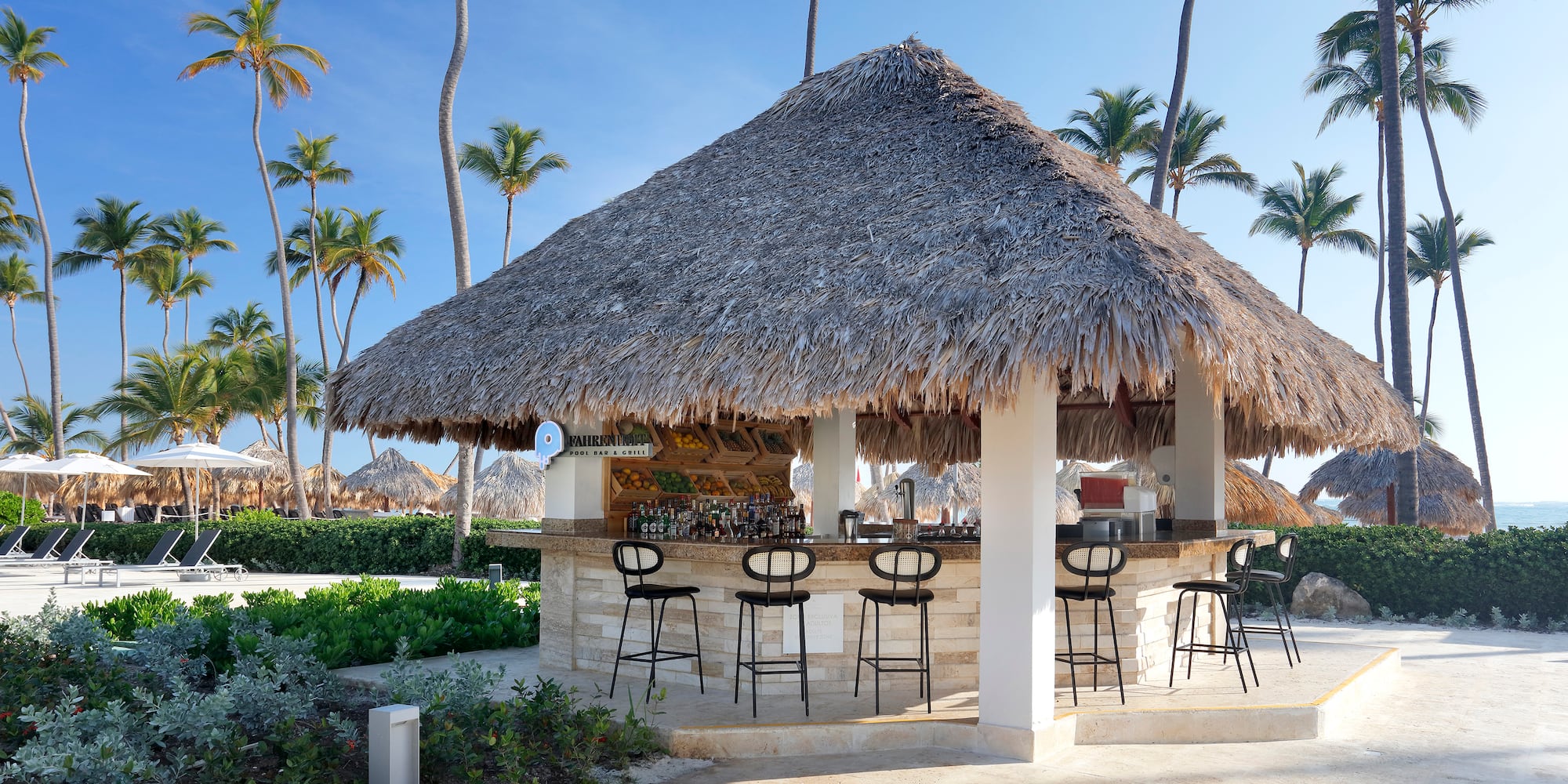 a bar with stools and chairs on a beach