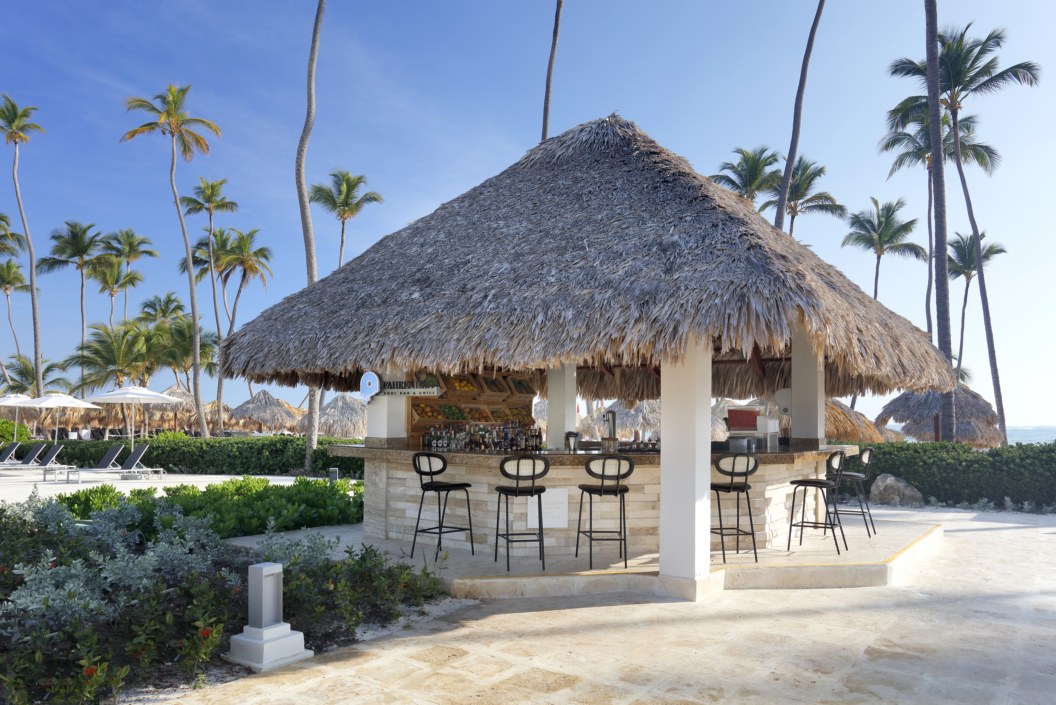 a bar with stools and chairs on a beach