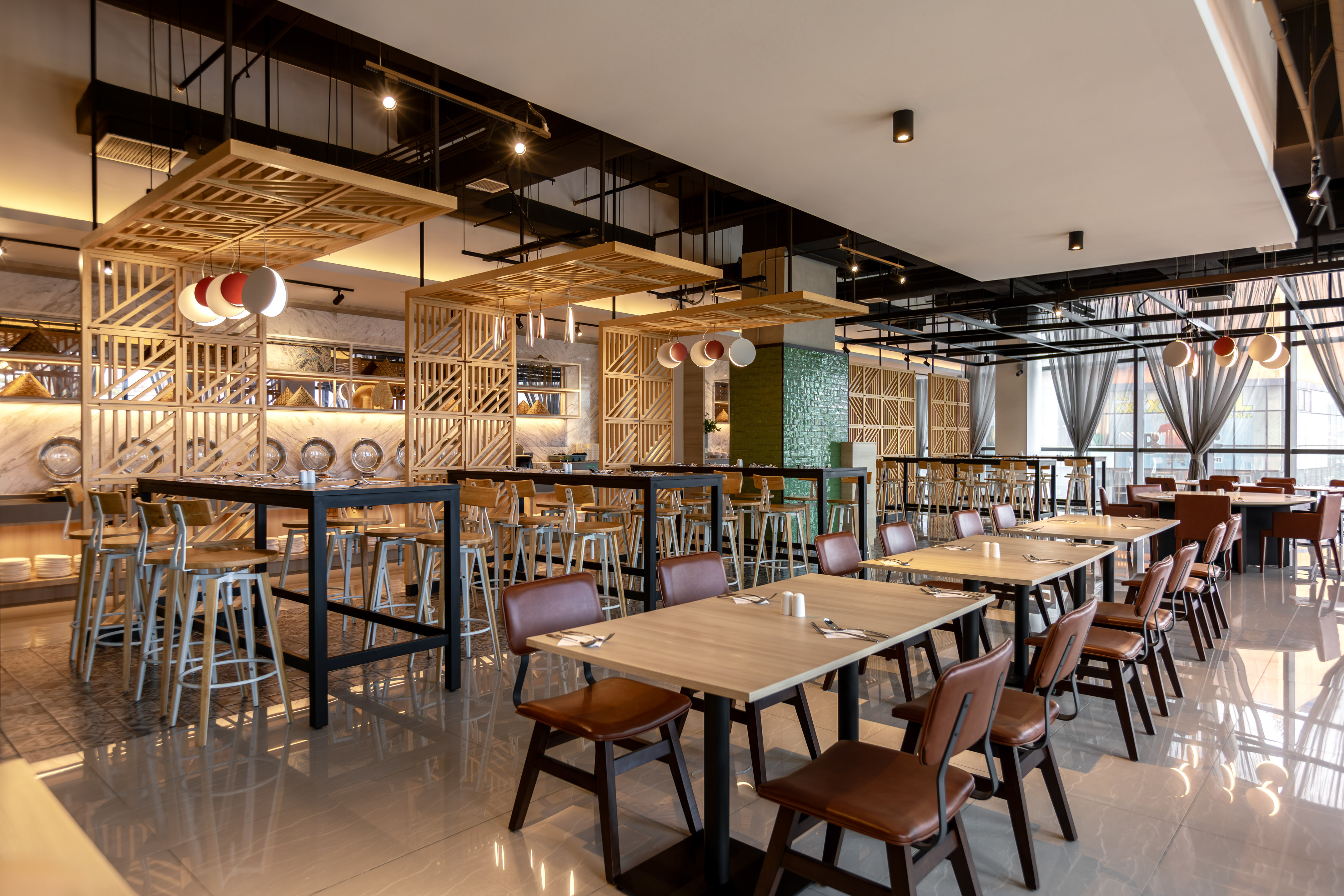 Modern restaurant interior with wooden slat partitions and diverse seating arrangements.