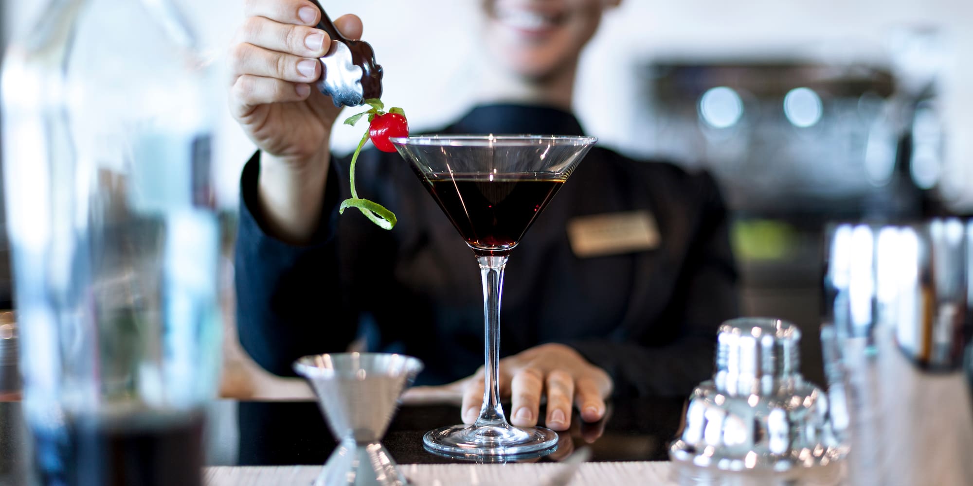 a person pouring a drink into a glass