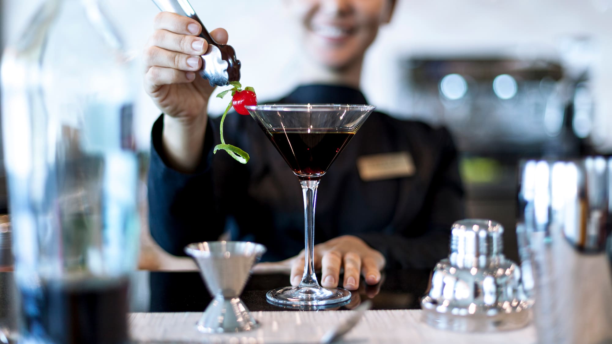 a person pouring a drink into a glass