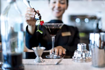 a person pouring a drink into a glass