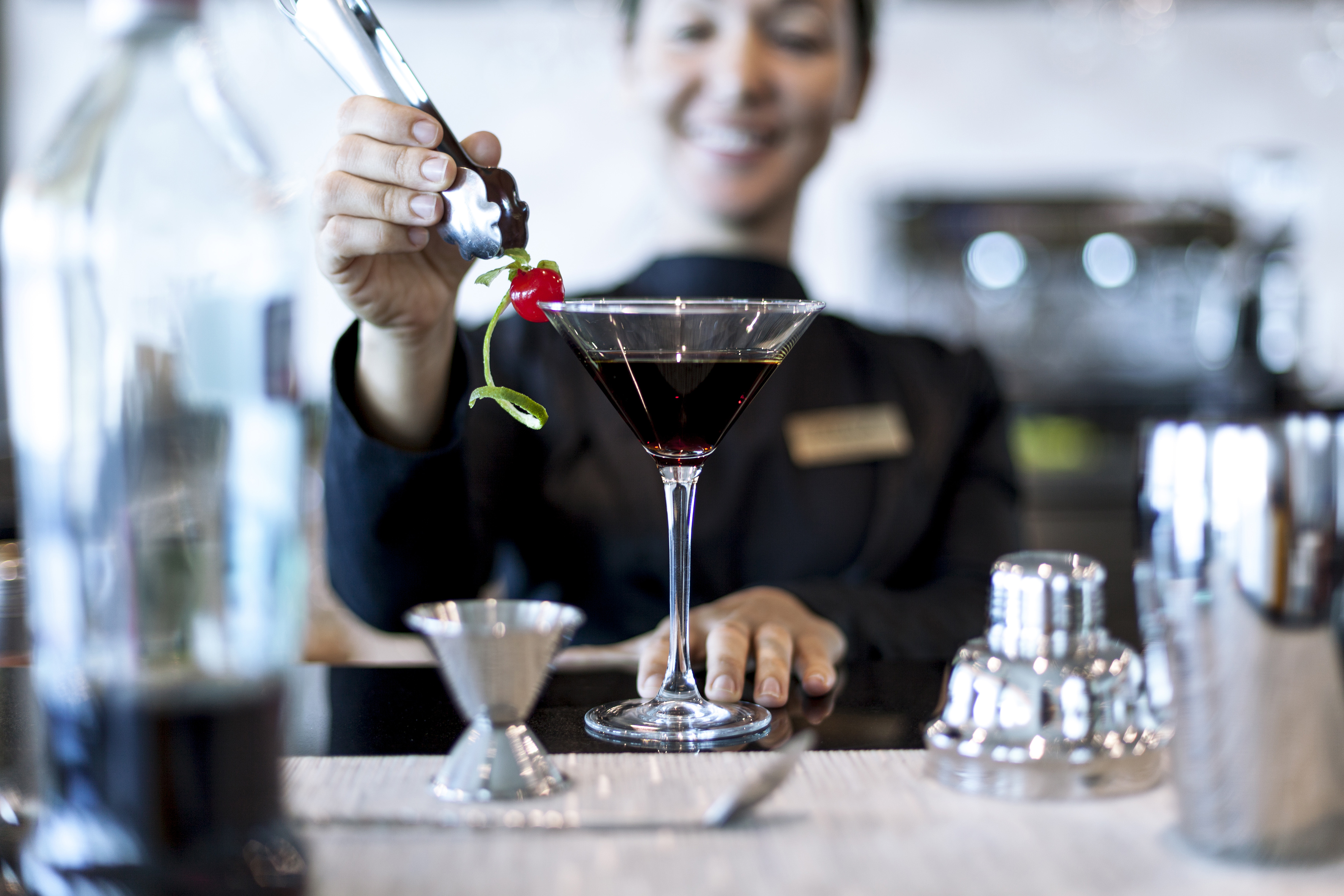 a person pouring a drink into a glass