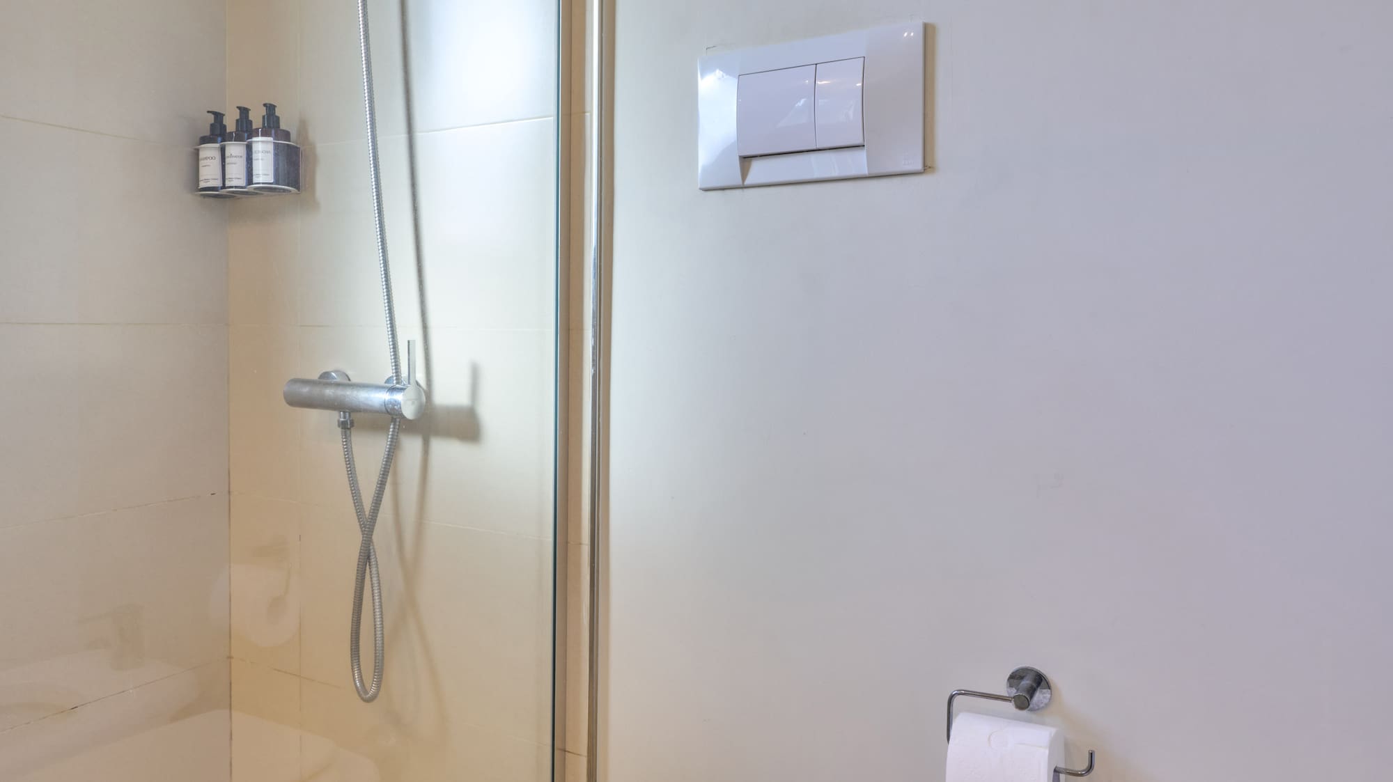 Clean bathroom interior with glass shower, toilet, and bidet.