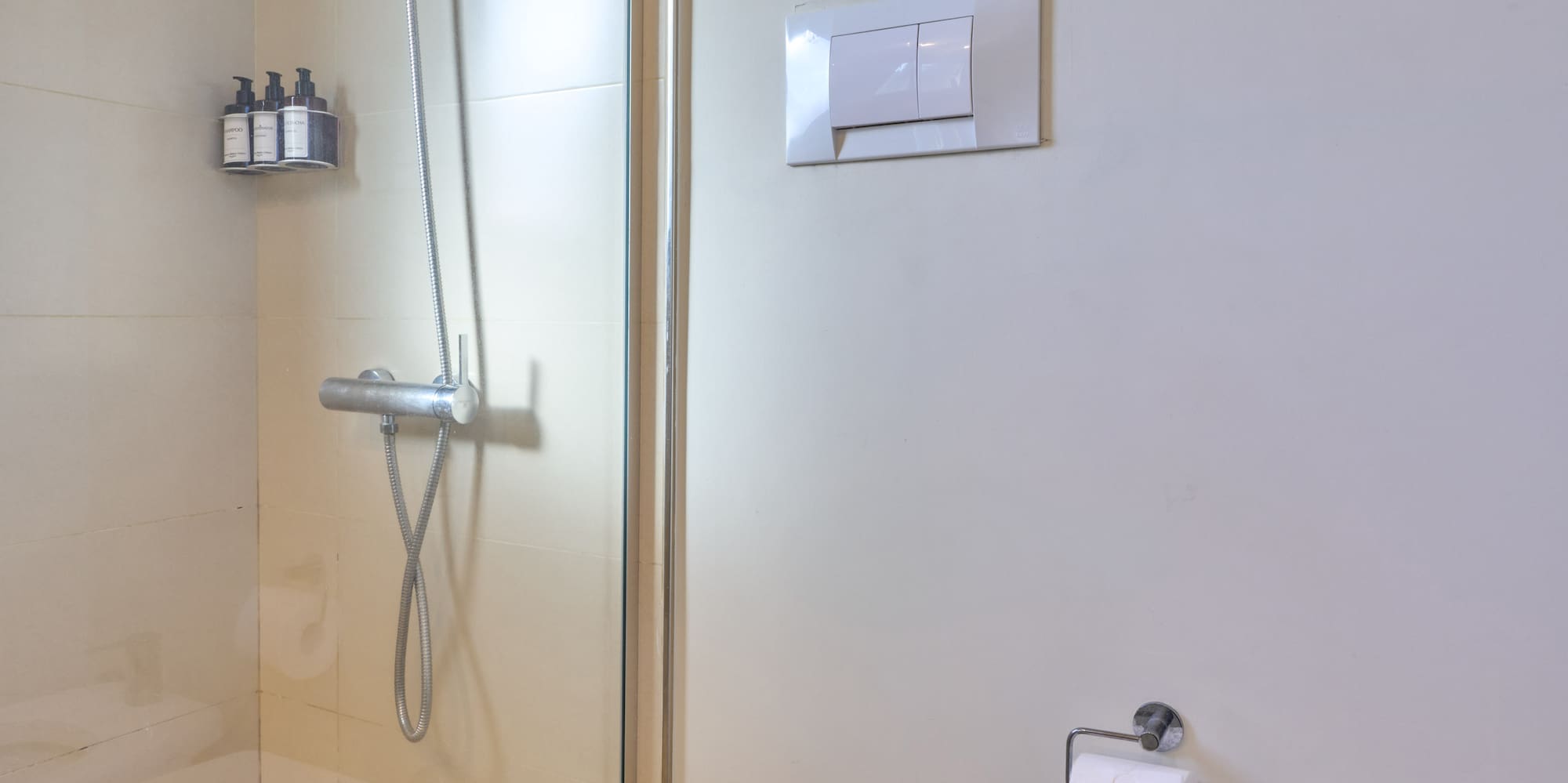 Clean bathroom interior with glass shower, toilet, and bidet.