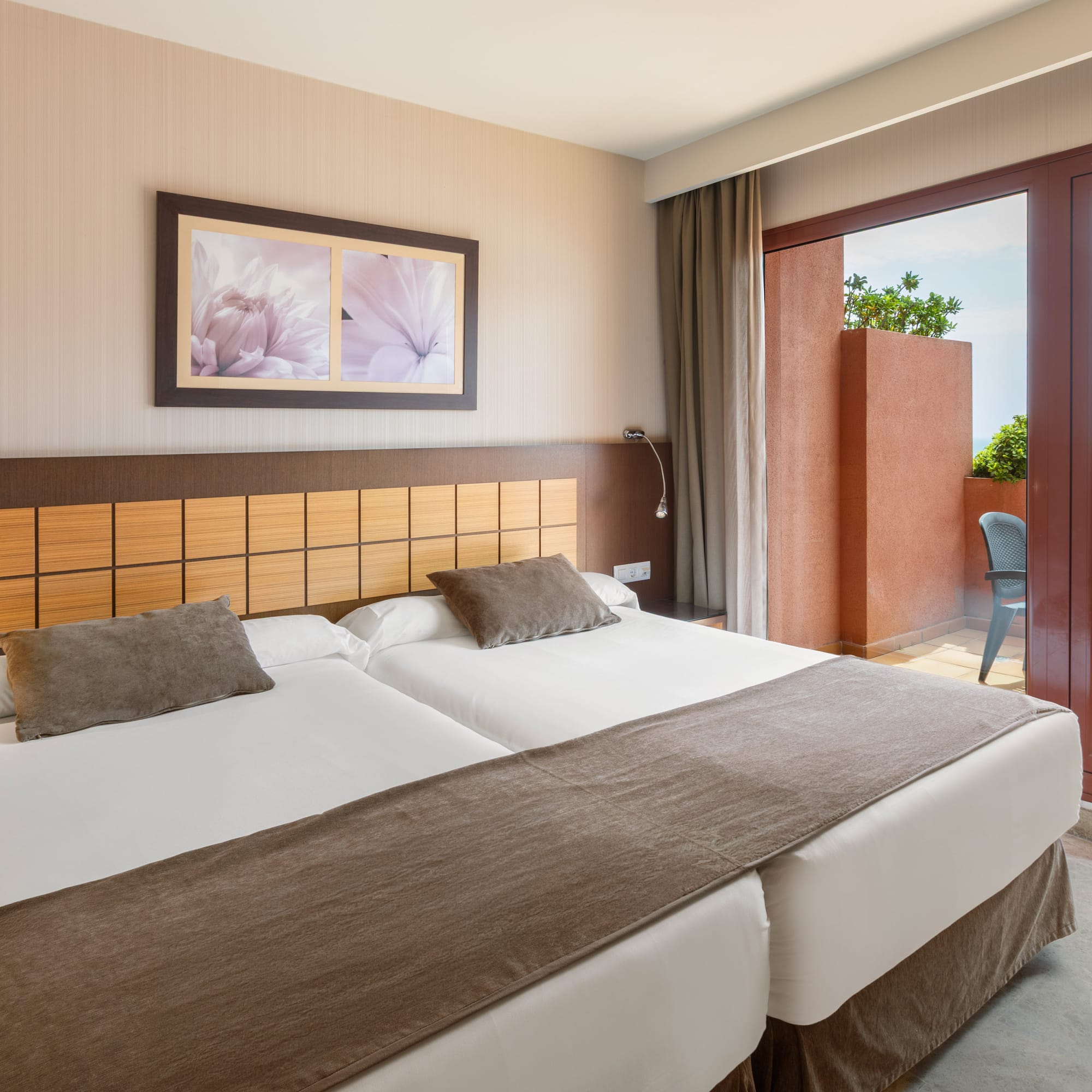 Hotel room with twin beds, private balcony, and sea view.