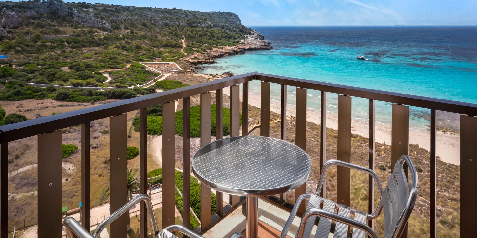 a table and chairs on a balcony overlooking a body of water