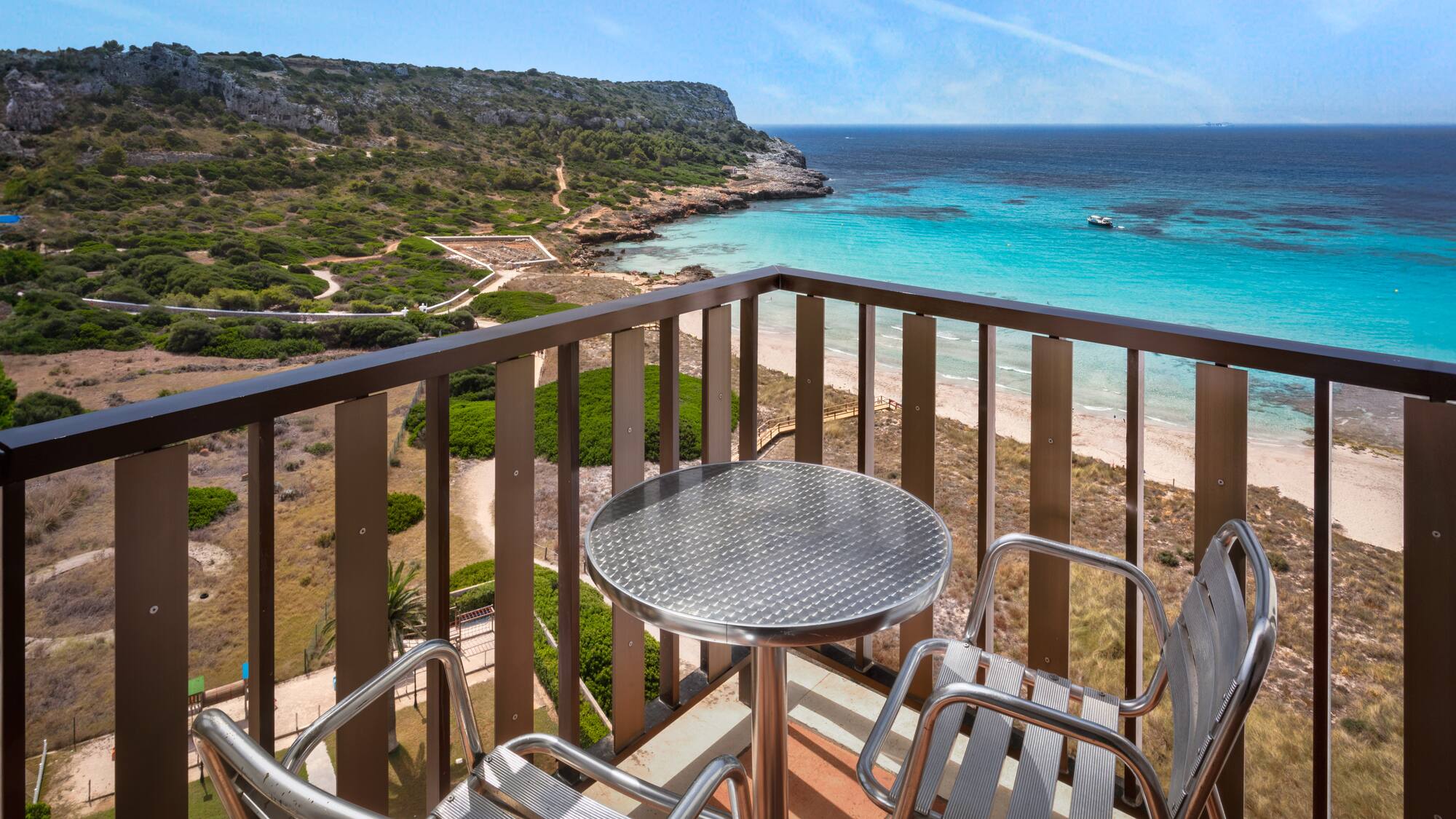a table and chairs on a balcony overlooking a body of water