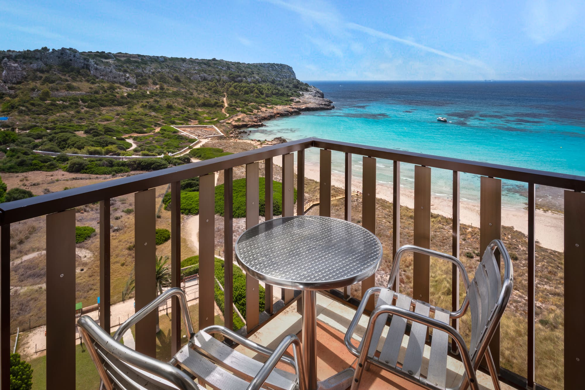 a table and chairs on a balcony overlooking a body of water