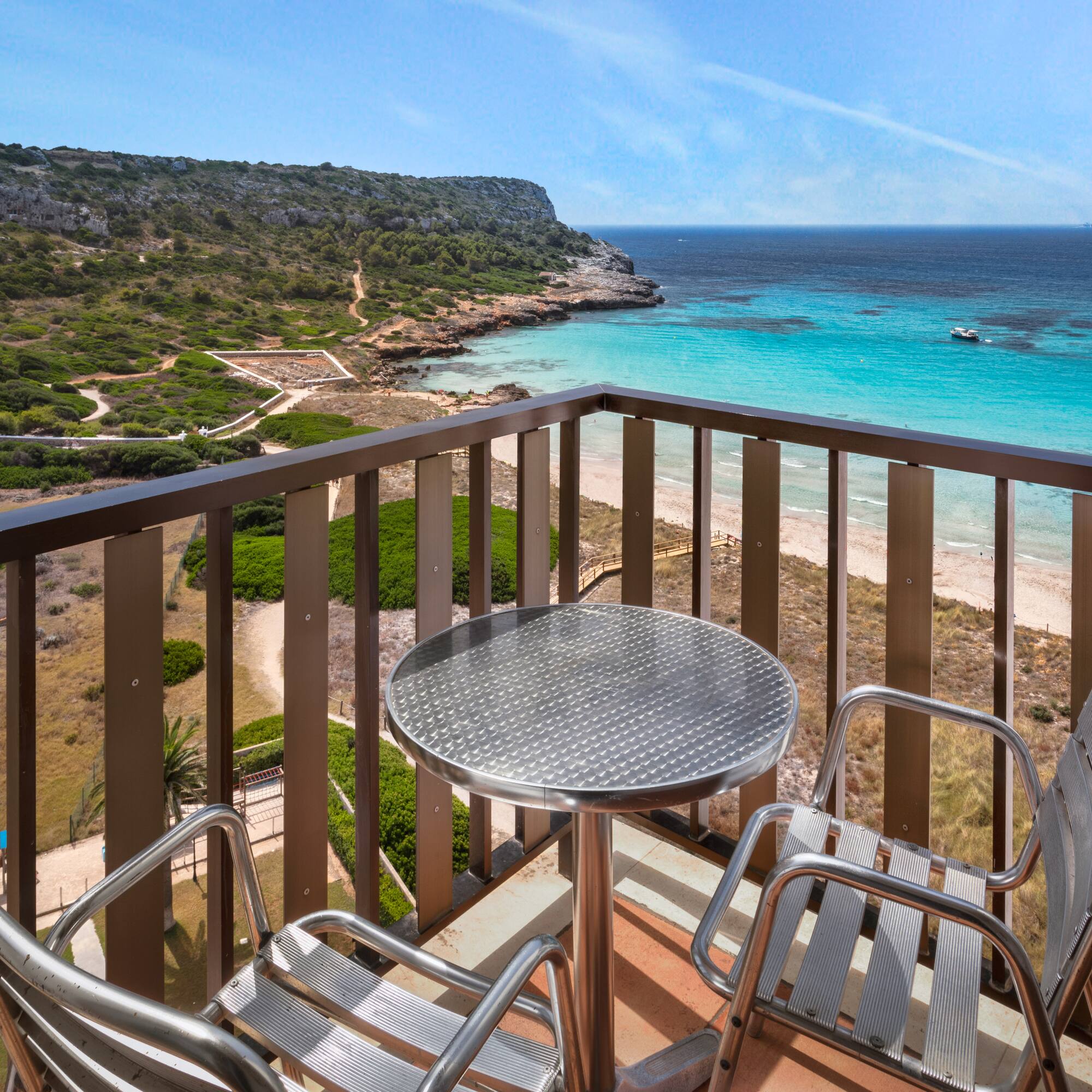 a table and chairs on a balcony overlooking a body of water