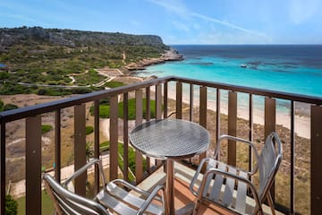 a table and chairs on a balcony overlooking a body of water