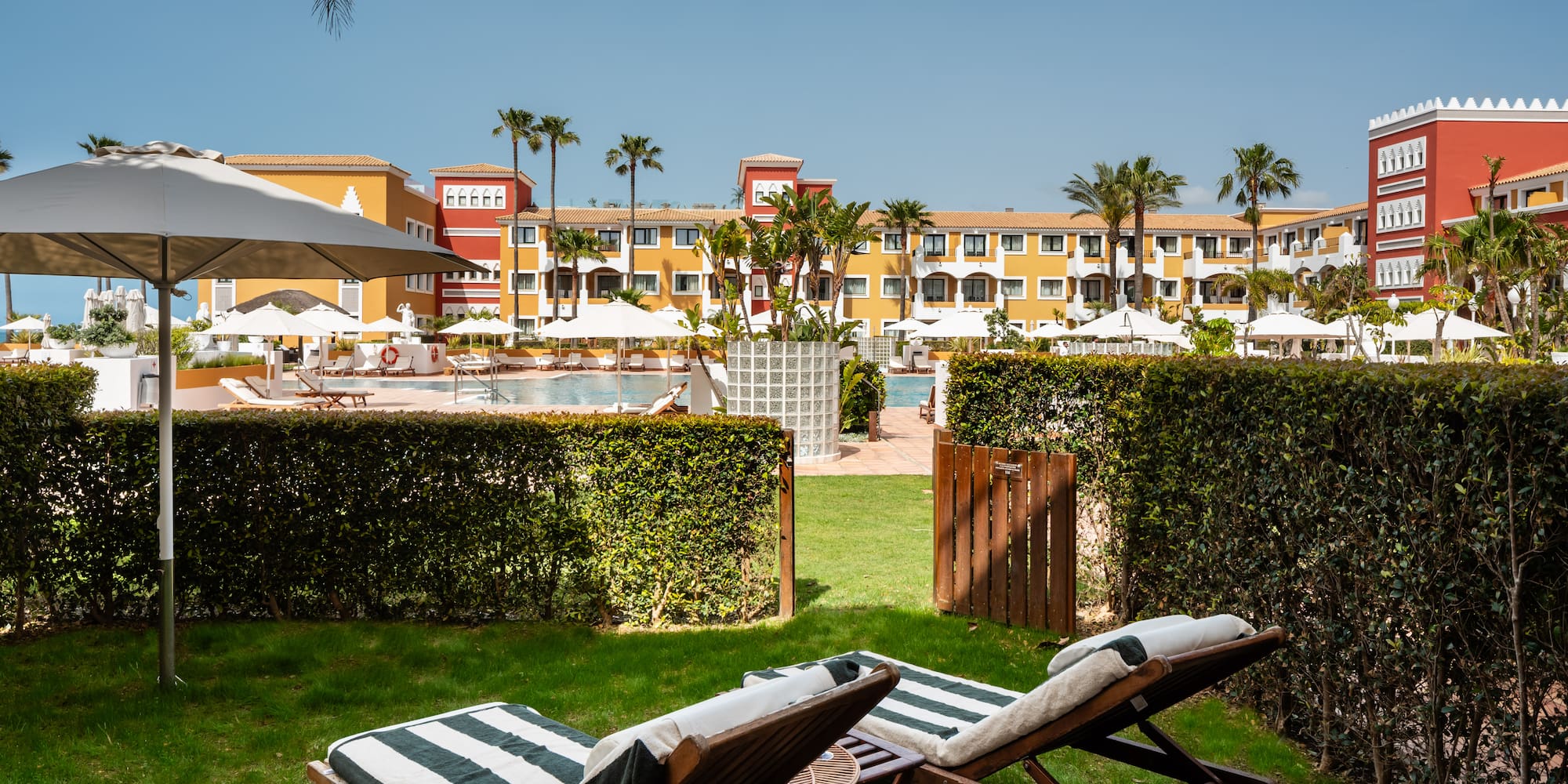 chairs in a yard with a pool in the background