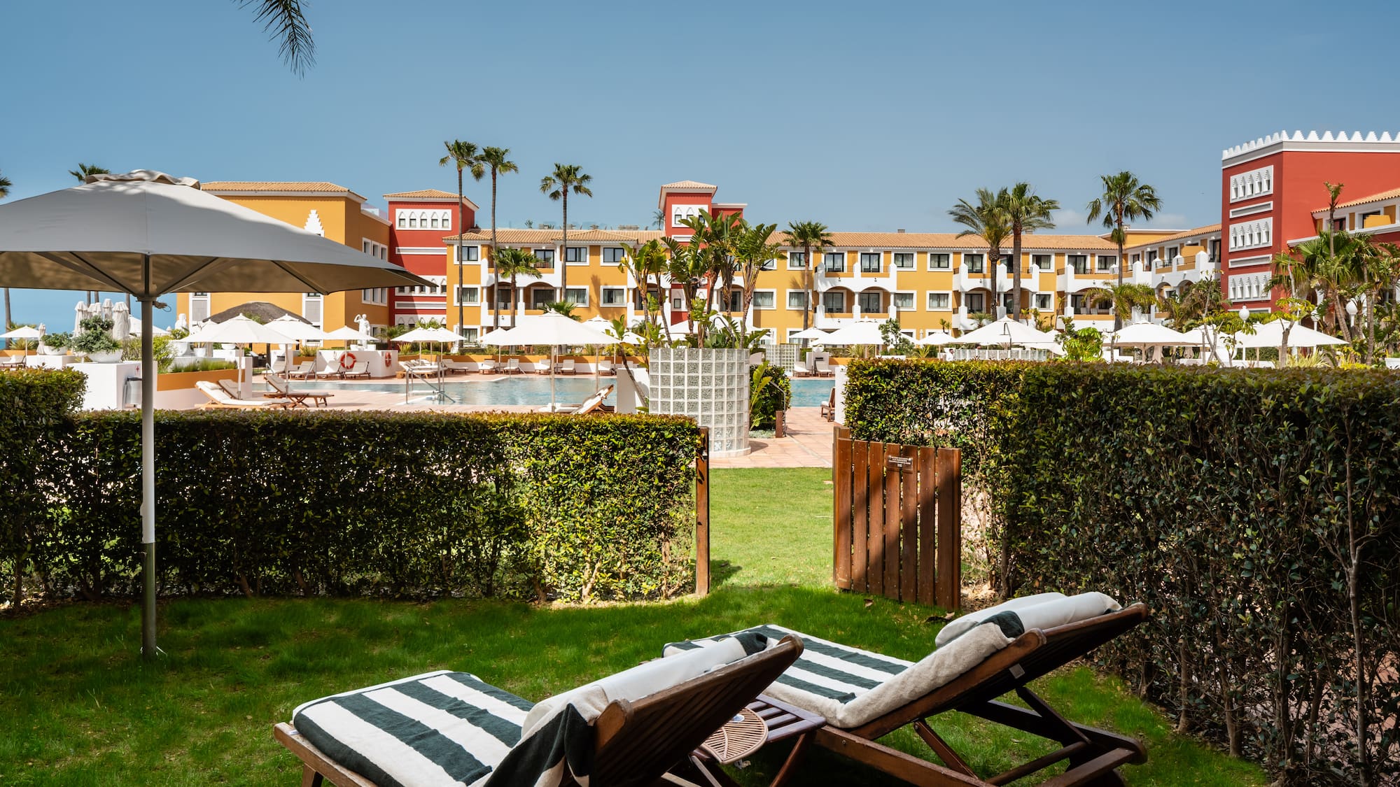 chairs in a yard with a pool in the background