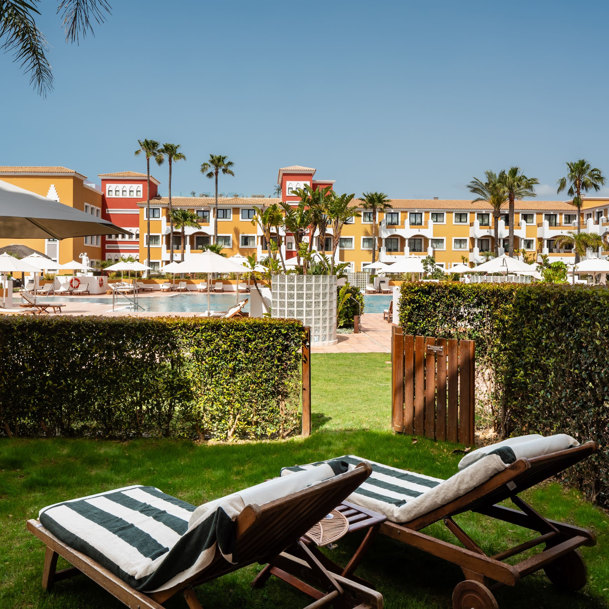 chairs in a yard with a pool in the background