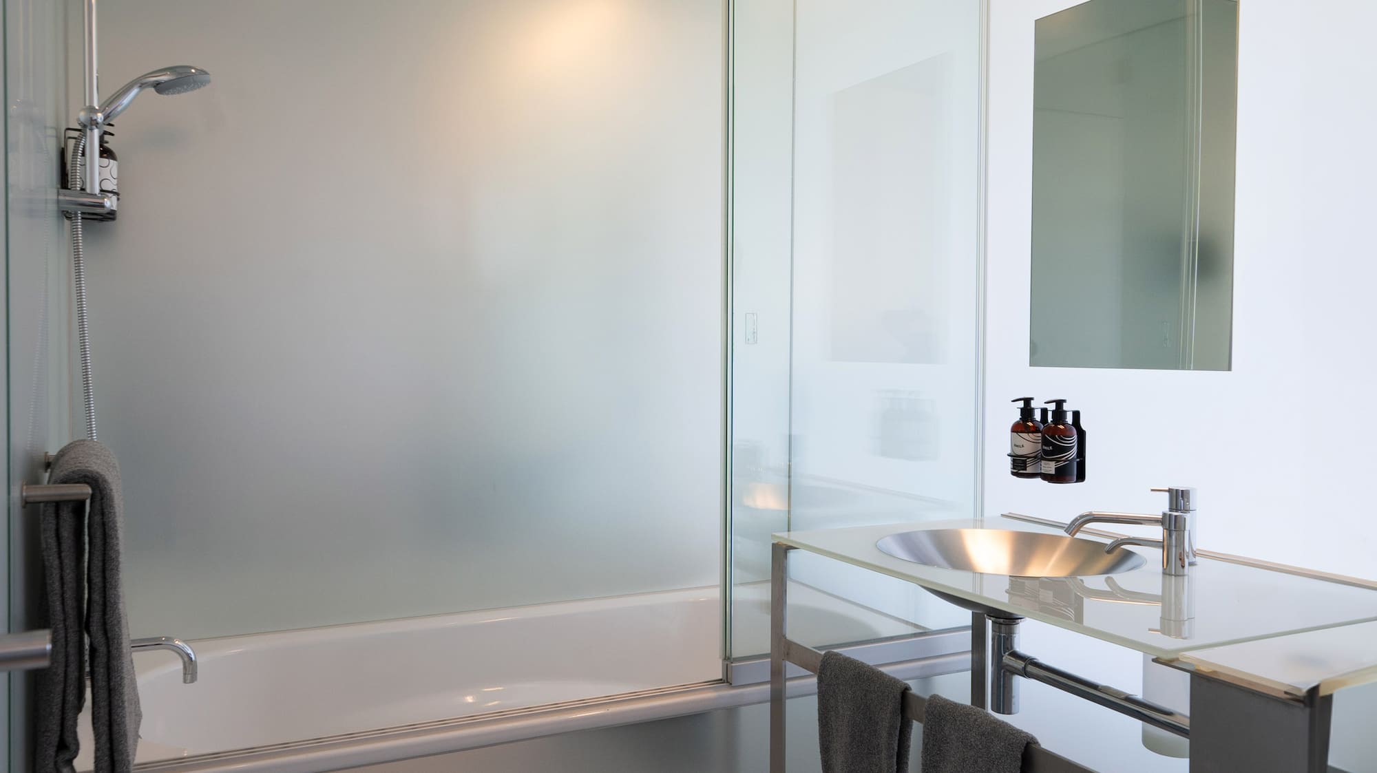 a bathroom with a glass shower and sink