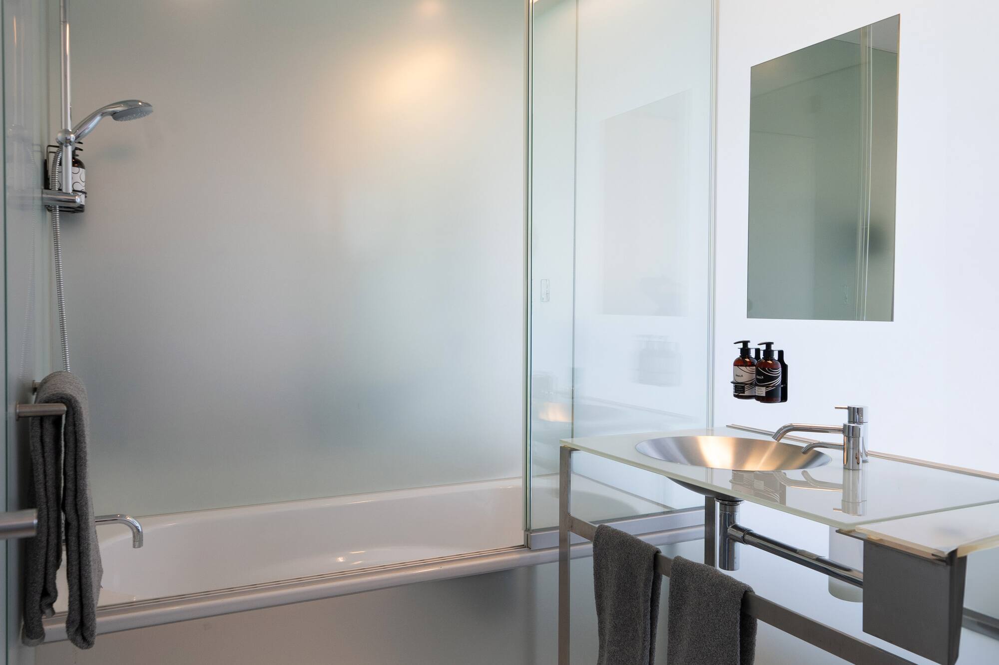 a bathroom with a glass shower and sink