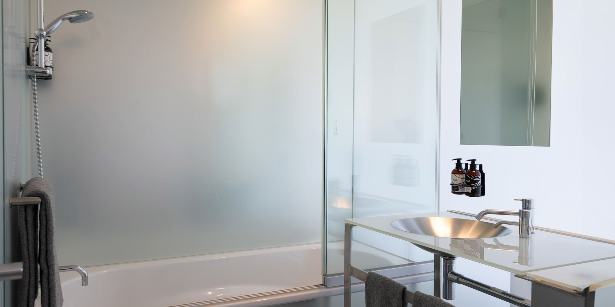 a bathroom with a glass shower and sink