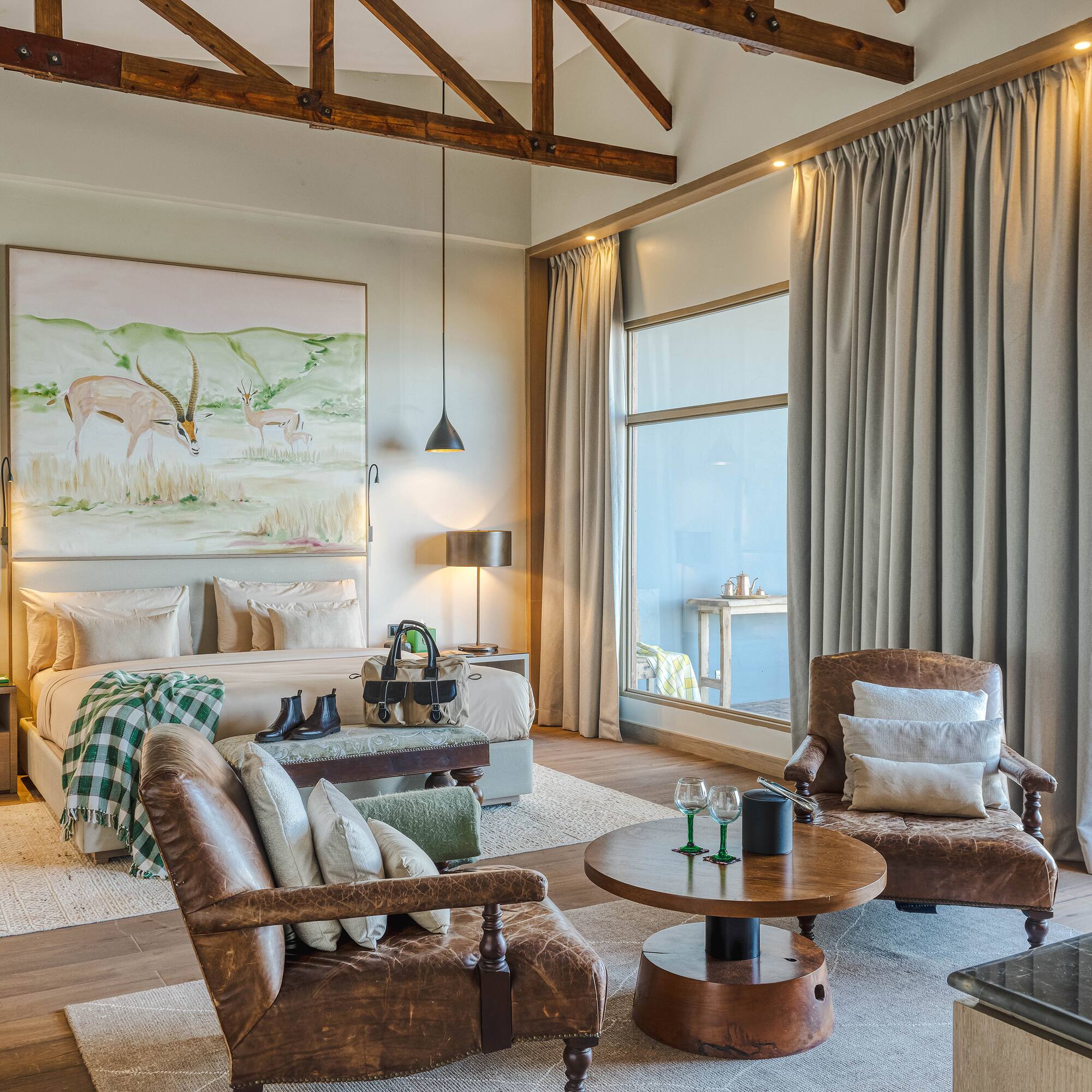 a room with a bed and chairs