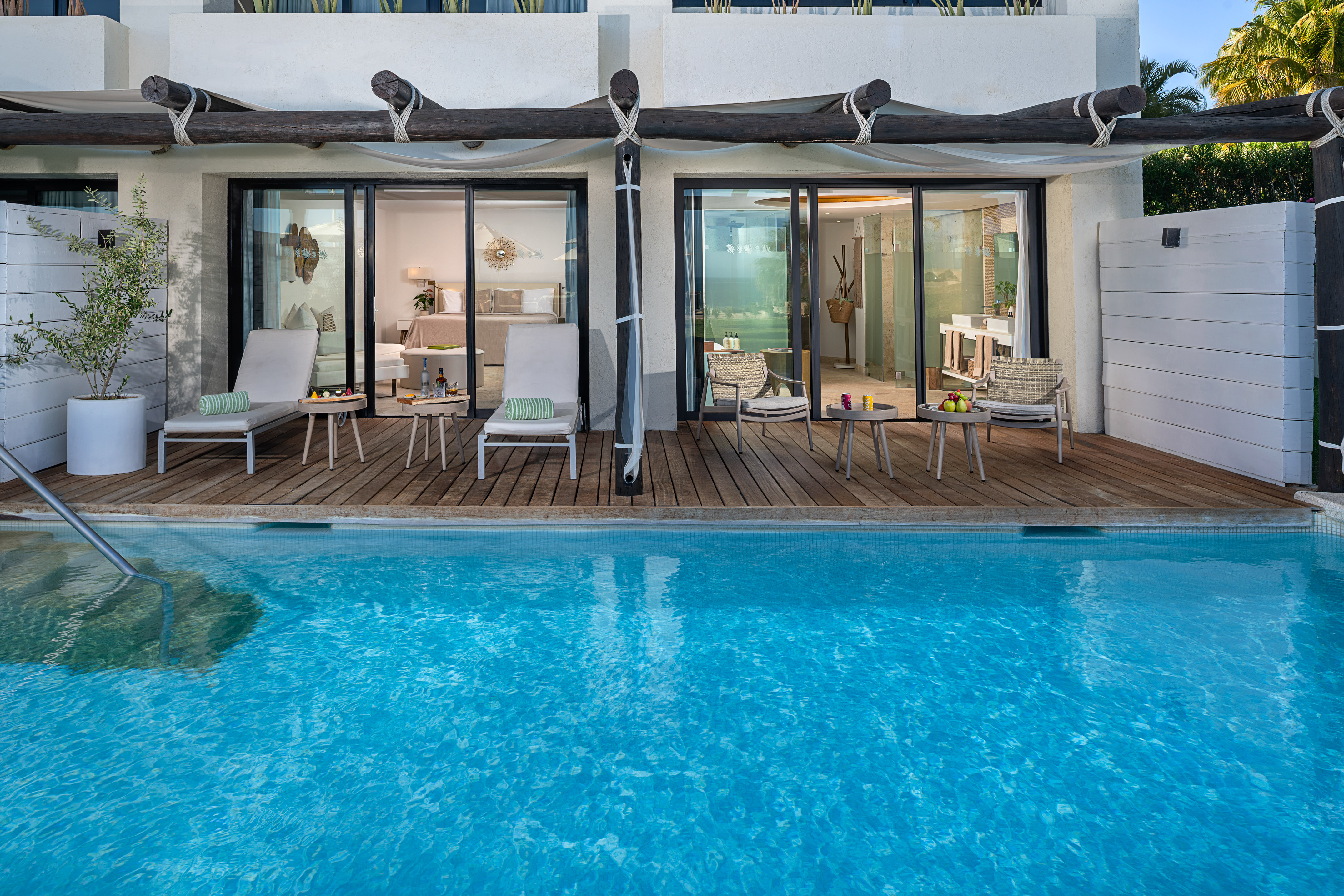 Luxury resort swim-up suite with deck, lounge chairs, and private pool.