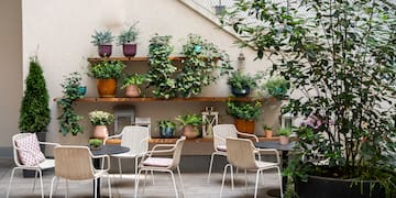 a patio with chairs and tables and potted plants