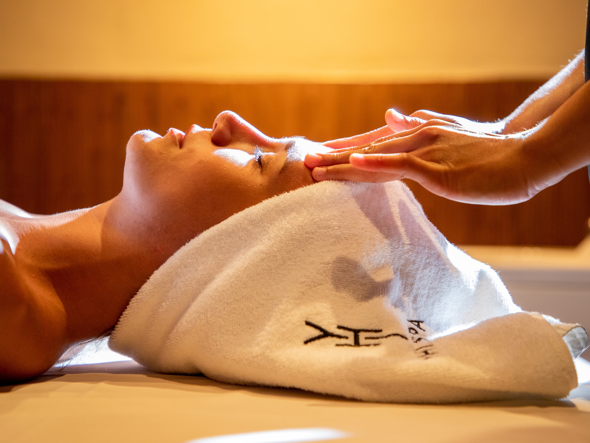 a person lying down with a towel on their head