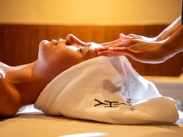 a person lying down with a towel on their head