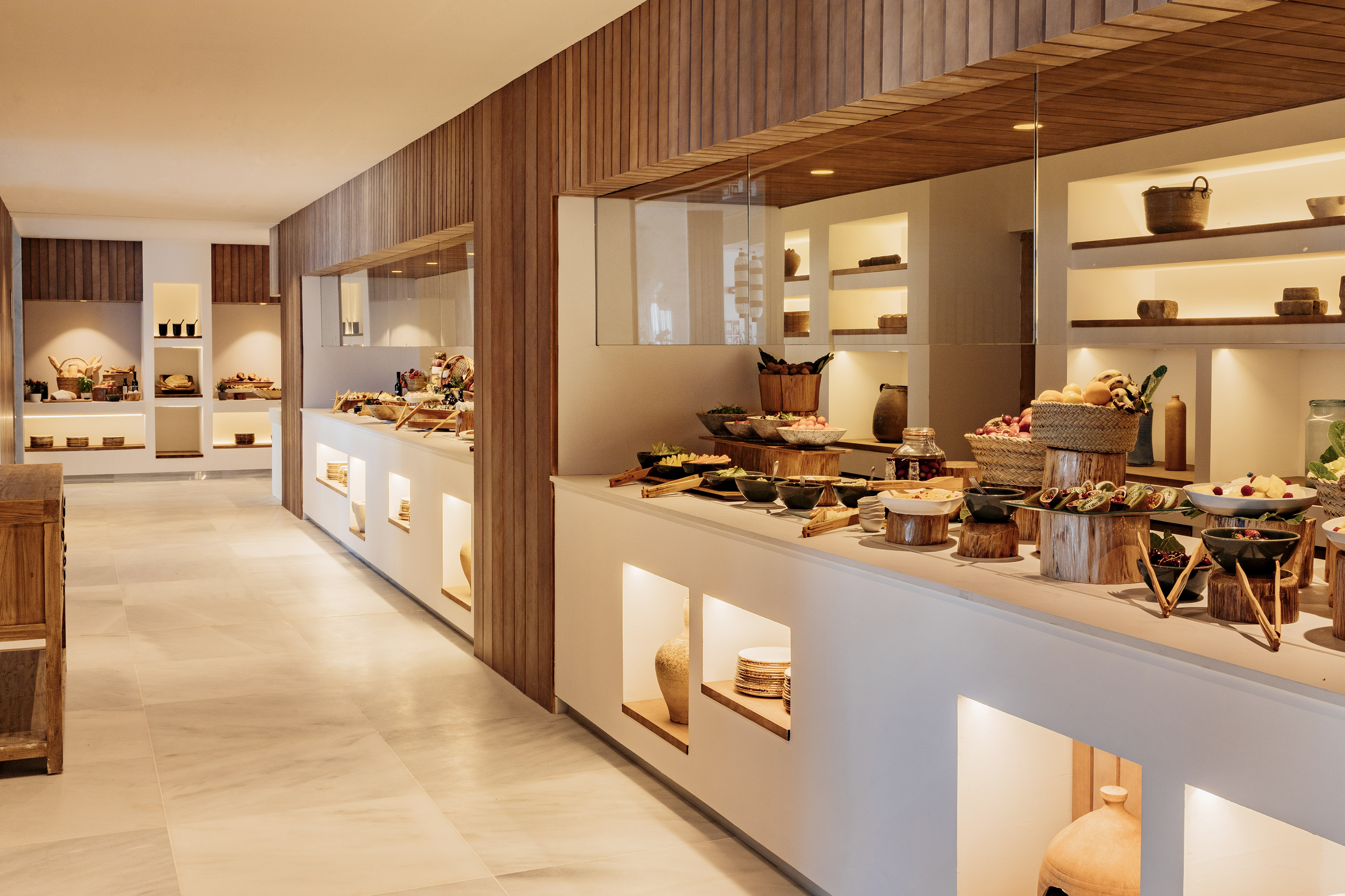 Modern hotel buffet with fresh food, warm lighting, and wooden accents.