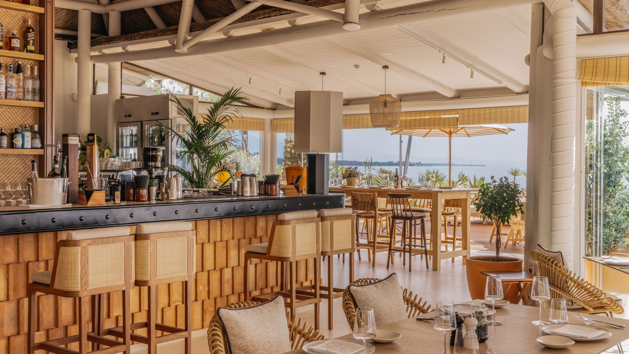 Waterfront restaurant and bar with rattan furniture and lake view.